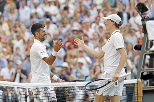 Jannik Sinner (R) of Italy shakes hands with Novak Djokovic of Serbia