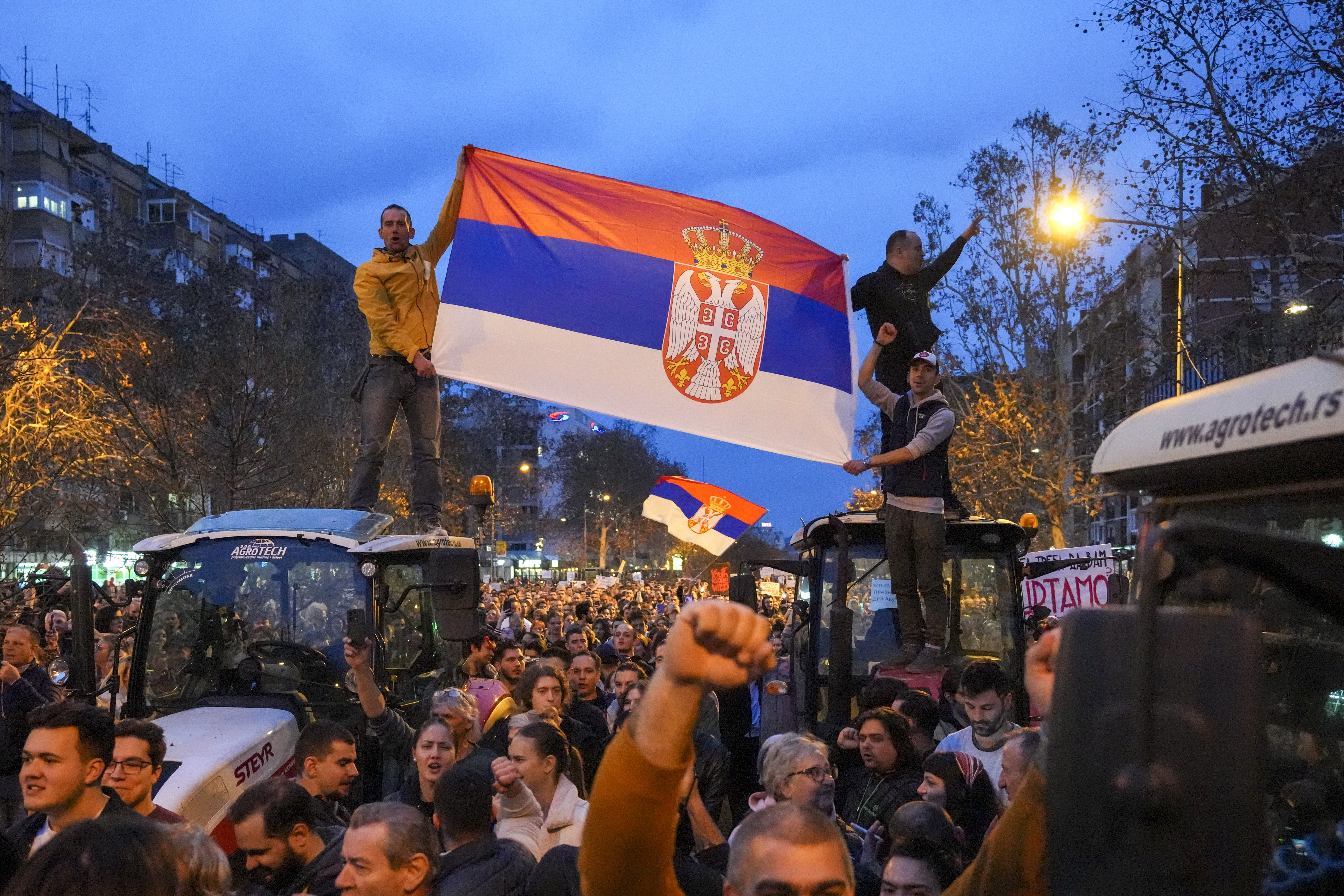 People hold a Serbian flag during a protest, day after the assault on students was carried out by thugs with baseball bats, in Novi Sad, Serbia, Tuesday, Jan. 28, 2025. (AP Photo/Darko Vojinovic)