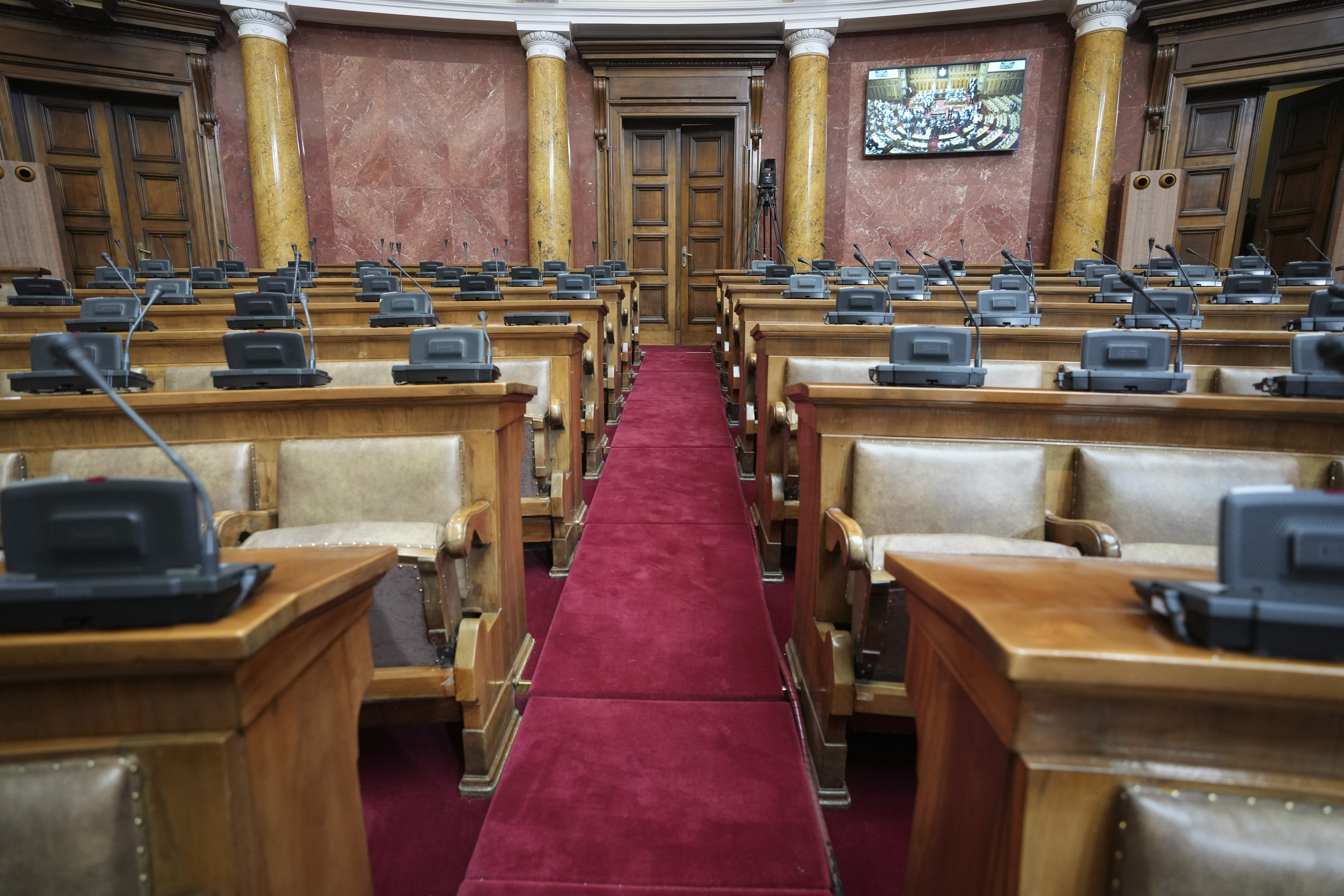 Empty seats of opposition are seen on the parliament floor during a parliament session a day after clashes erupted between the members of the parliament in Belgrade, Serbia, Wednesday, March 5, 2025. (AP Photo/Darko Vojinovic)
