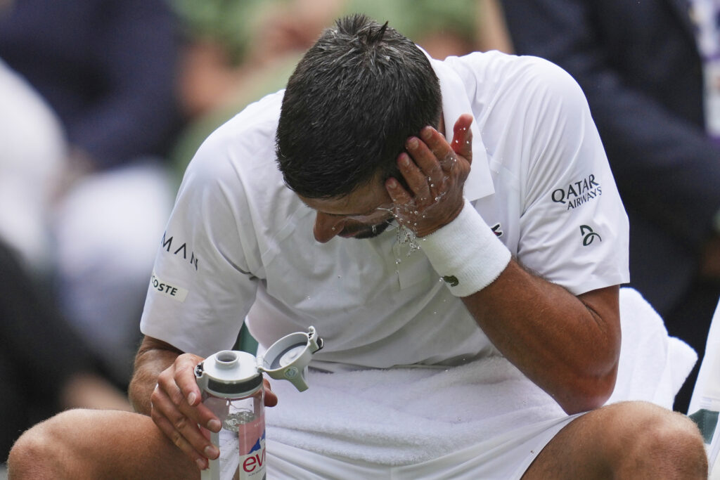 Serbia's Novak Djokovic douses himself in water to cool down during a break in play against Australia's Alex de Minaur during a fourth round men's singles match at the Wimbledon Tennis Championships in London, Monday, July 7, 2025. (AP Photo/Kin Cheung)