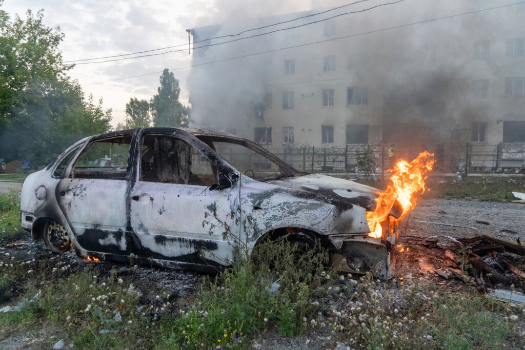 A car burns against the background of a damaged residential building following Russia's missile attack in Kharkiv, Ukraine, Monday, Aug. 18, 2025. (AP Photo/Andrii Marienko)