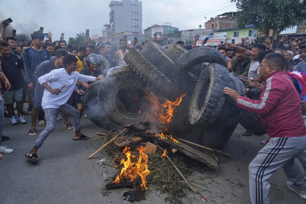Protesters burn tires violating the curfew orders in Kathmandu, Nepal, Tuesday, Sept. 9, 2025. (AP Photo/Niranjan Shrestha)