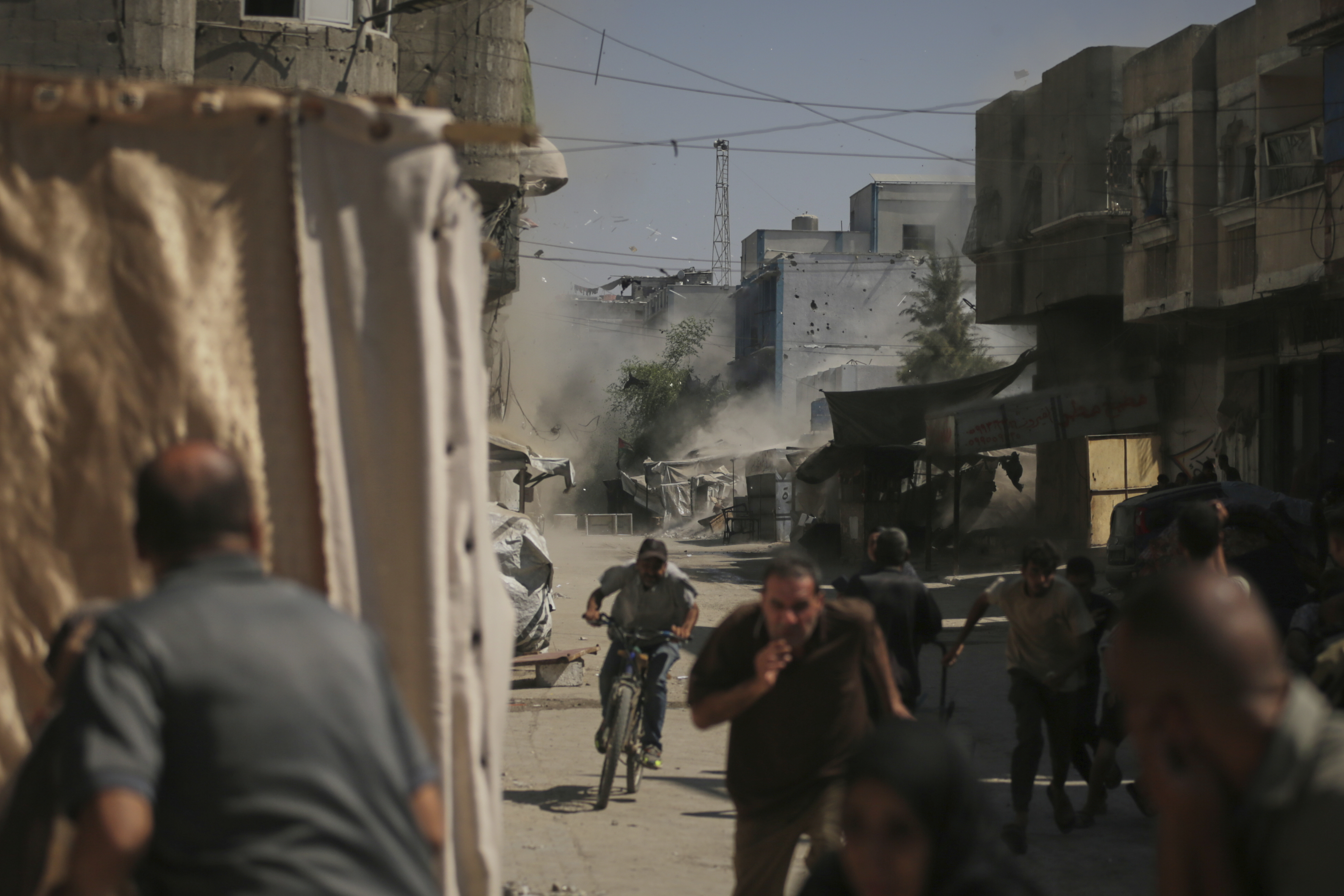 Palestinians run for cover during an Israeli military strike on a building in Gaza City, Saturday, Sept. 13, 2025. (AP Photo/Yousef Al Zanoun)