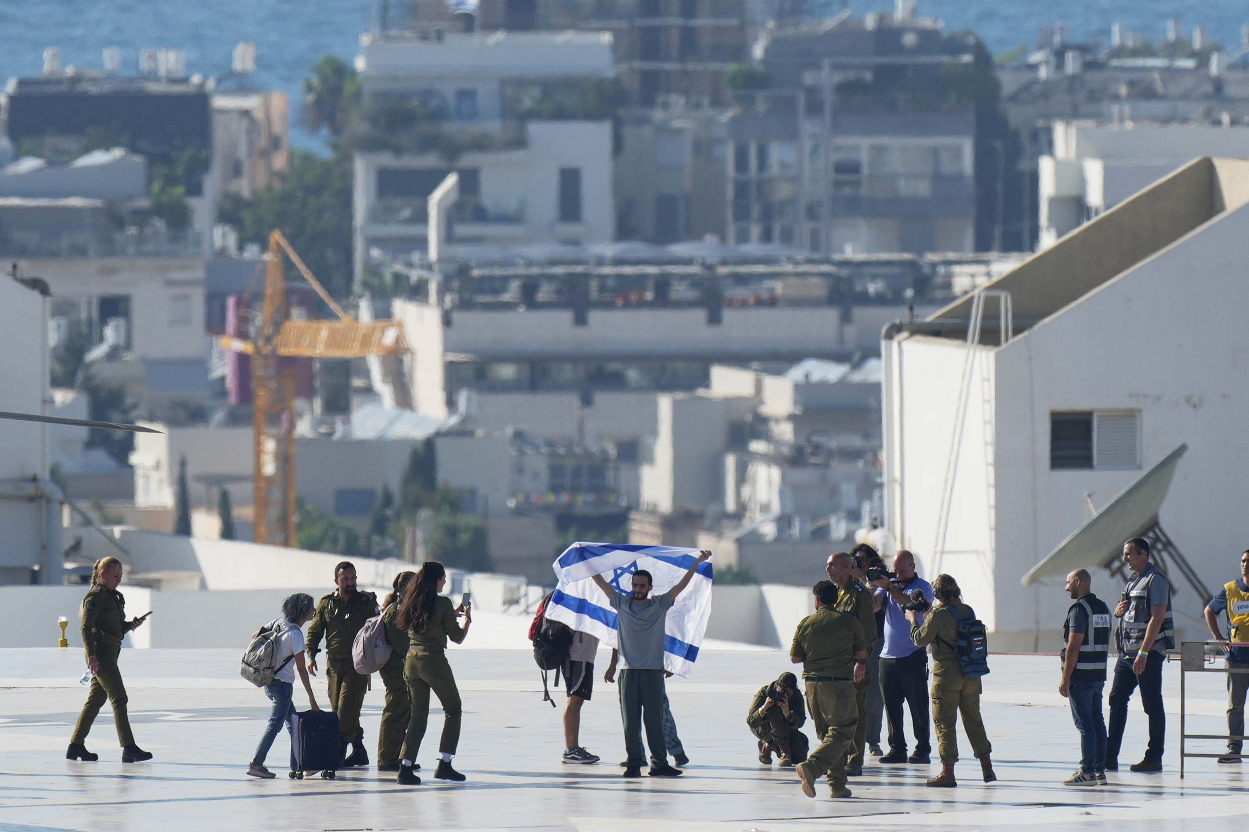 Nimrod Cohen, an Israeli hostage released from the Gaza Strip holds an Israeli flag after coming off a helicopter at the Ichilov Hospital, in Tel Aviv, Israel, Monday, Oct. 13, 2025. (AP Photo/Ohad Zwigenberg)