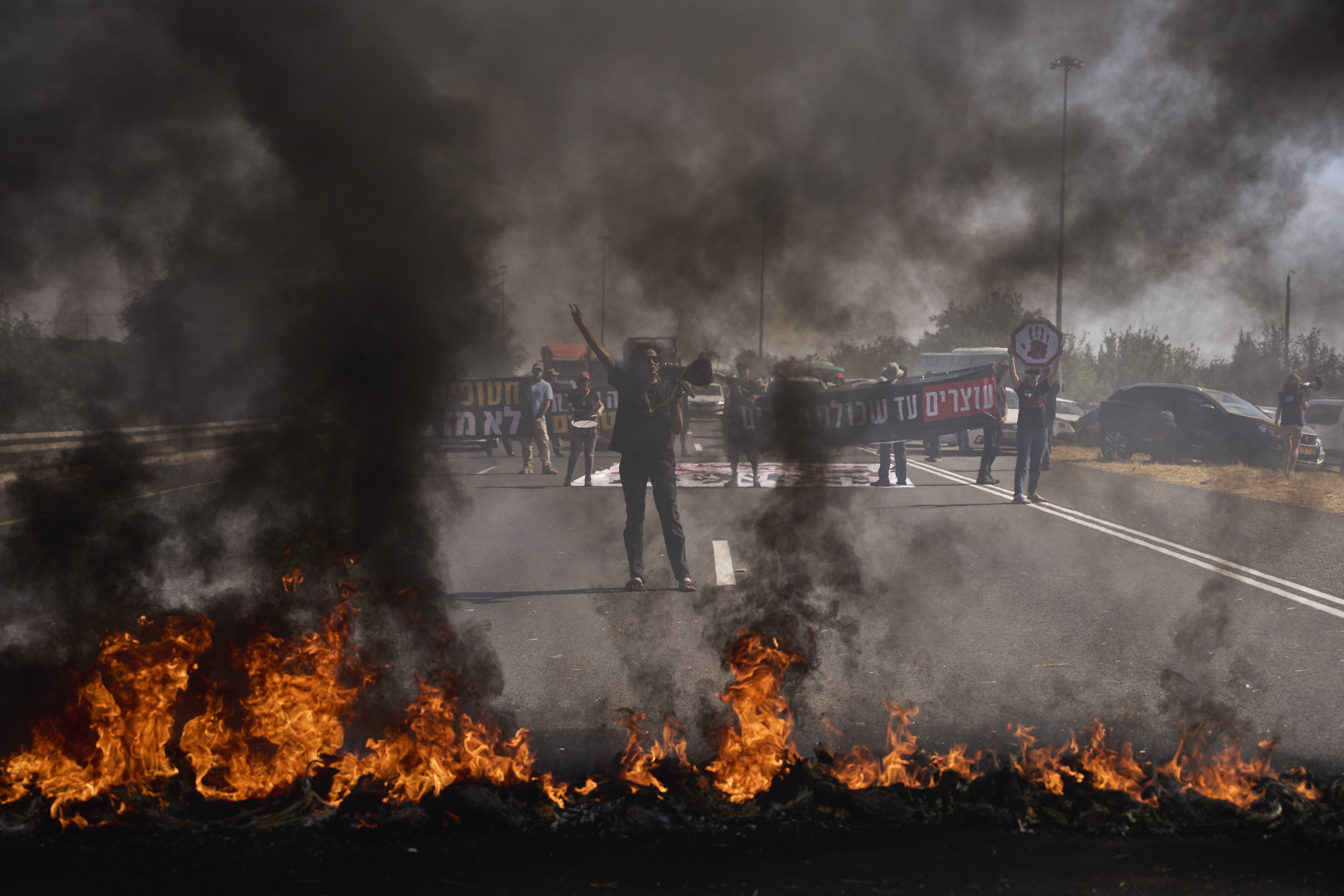 Demonstrators block a highway during a protest demanding the immediate release of all hostages held by Hamas and calling for the end of the war in the Gaza Strip, near Modiin, Israel, Tuesday, Aug. 26, 2025. (AP Photo/Ohad Zwigenberg)