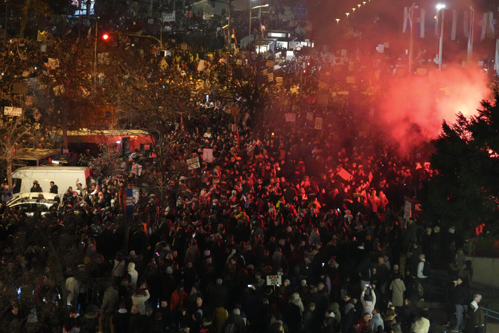 People light up flares as they gather for a protest over the collapse of a concrete canopy that killed 15 people more than two months ago, in Novi Sad, Serbia, Saturday, Feb. 1, 2025. (AP Photo/Darko Vojinovic)