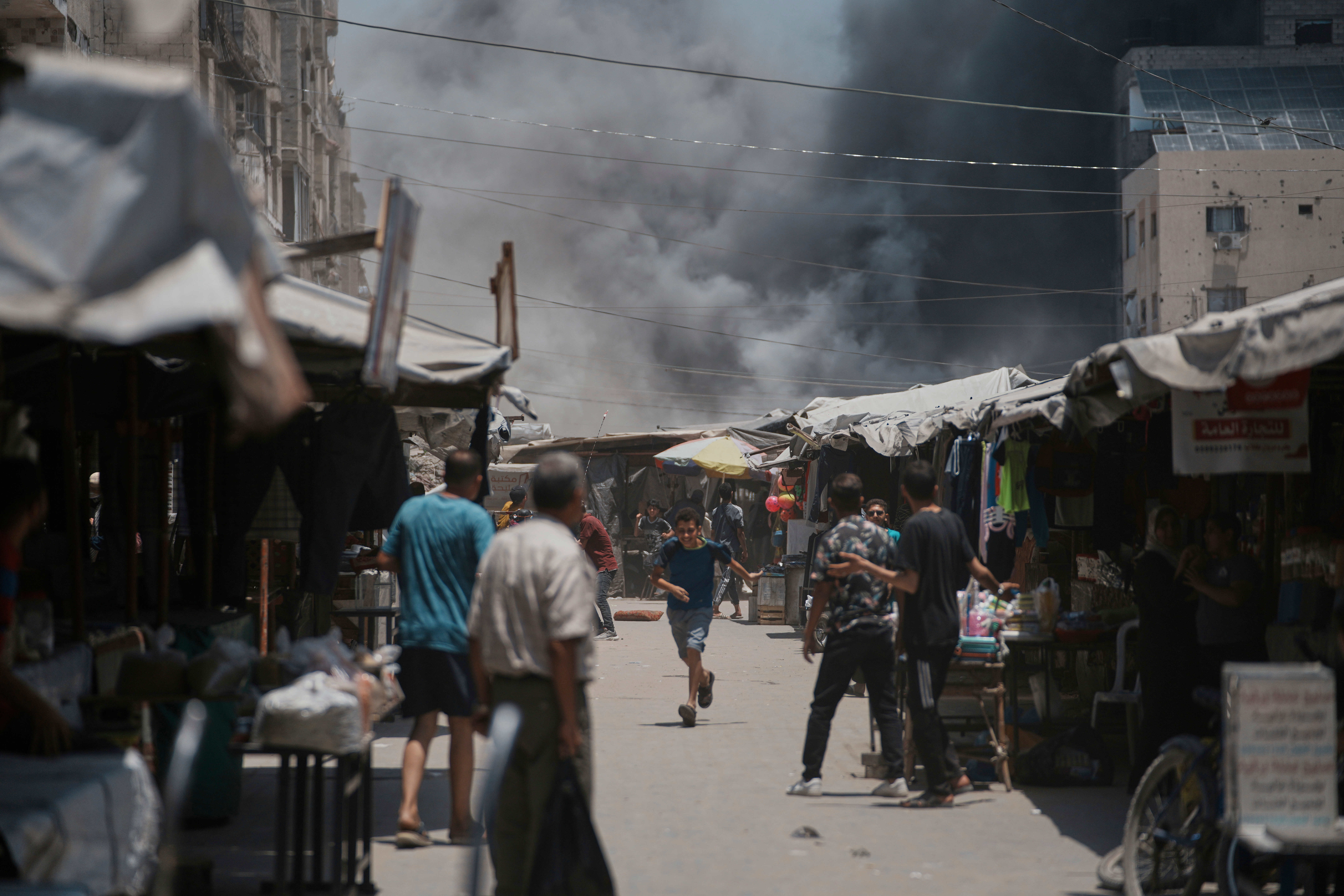 Palestinians look on as smoke rises to the sky following an Israeli strike in Gaza City, Sunday, June 1, 2025. (AP Photo/Jehad Alshrafi)