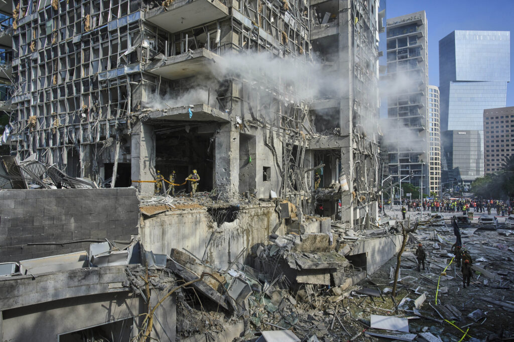 Rescue workers and military personnel inspect the site of a direct hit from an Iranian missile strike in Ramat Gan, Israel, Thursday, June 19, 2025. (AP Photo/Oded Balilty)