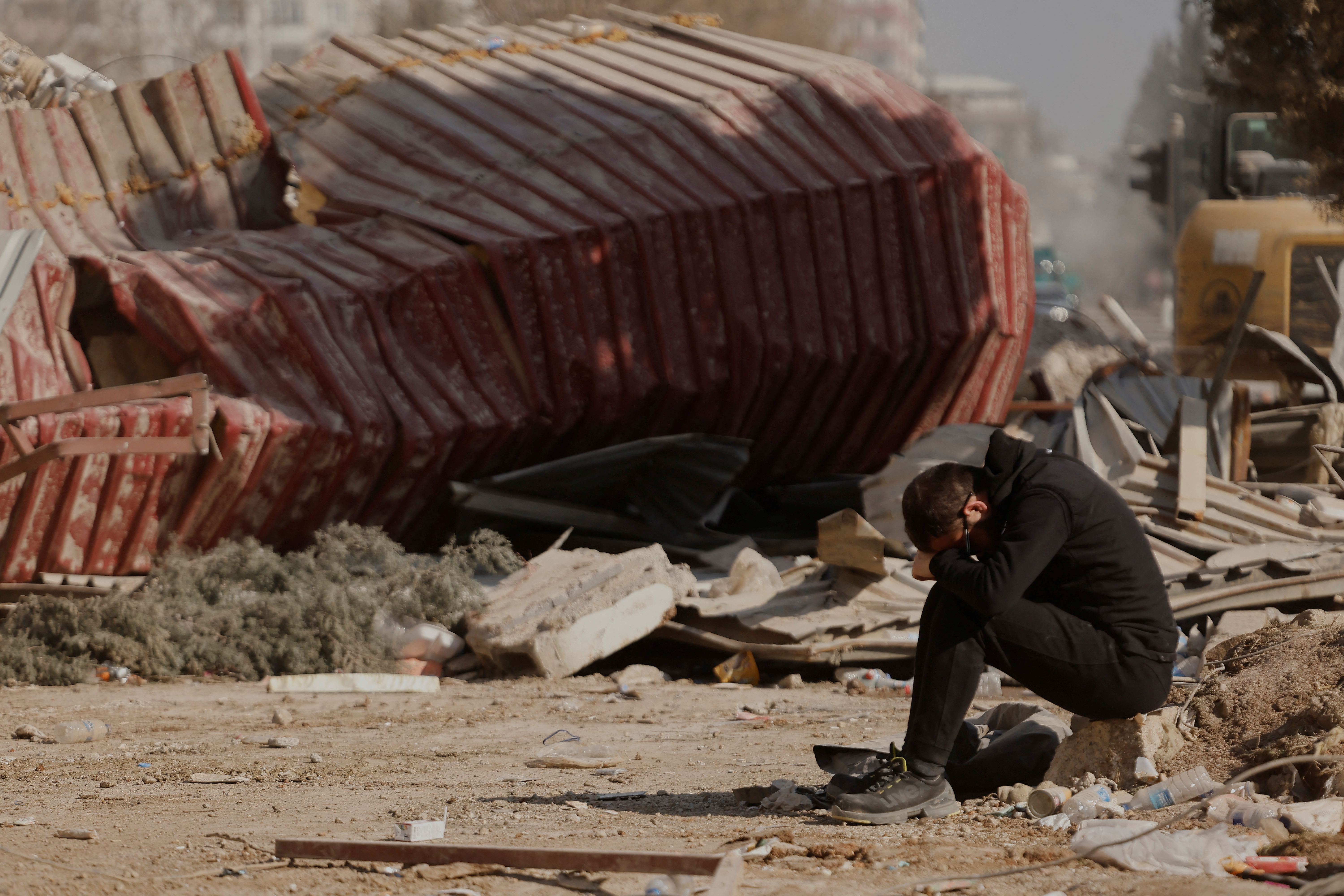 A man reacts as people search the rubble of collapsed apartment blocks for personal belongings, in the aftermath of a deadly earthquake, in Kahramanmaras, Turkey, February 18, 2023. REUTERS/Clodagh Kilcoyne