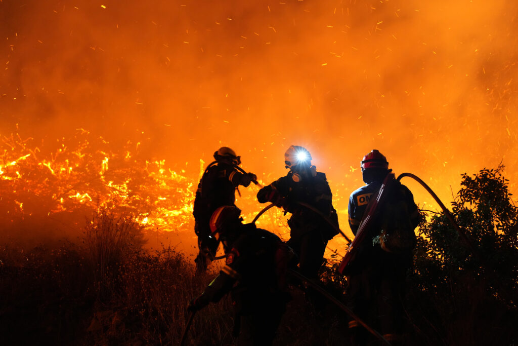 Firefighters battle with a large wildfire burning in Kofinas, on the eastern Aegean island of Chios, Greece, late Sunday, June 22, 2025. (Pantelis Fykaris/Politischios.gr via AP)