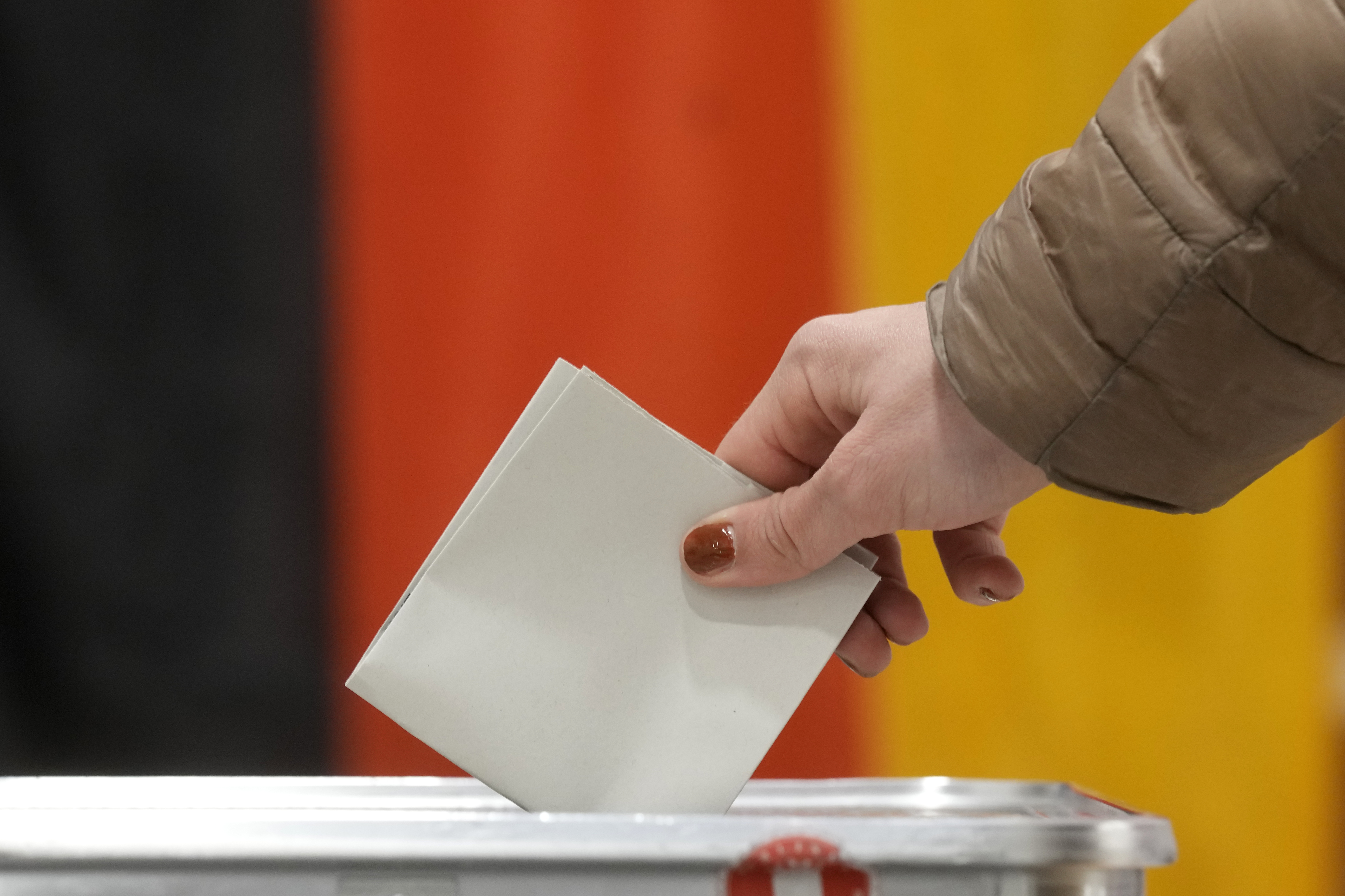 A resident casts a vote at a polling station in Berlin, Germany, Sunday, Feb. 23, 2025, during the German national election. (AP Photo/Michael Probst)