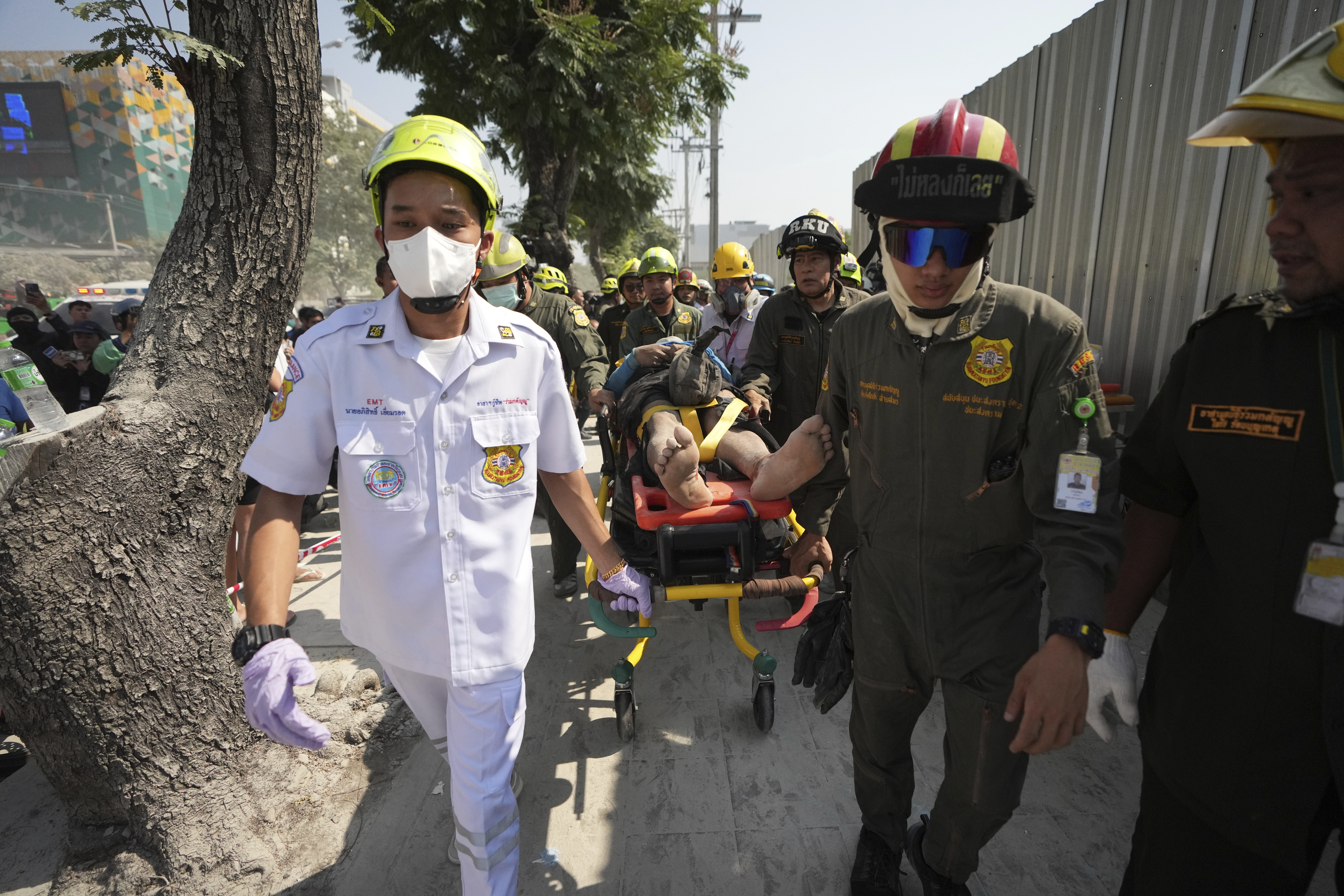 Rescuers carry an injured from the site of a high-rise building under construction that collapsed after a 7.7 magnitude earthquake in Bangkok, Thailand, Friday, March 28, 2025. (AP Photo/Sakchai Lalit)