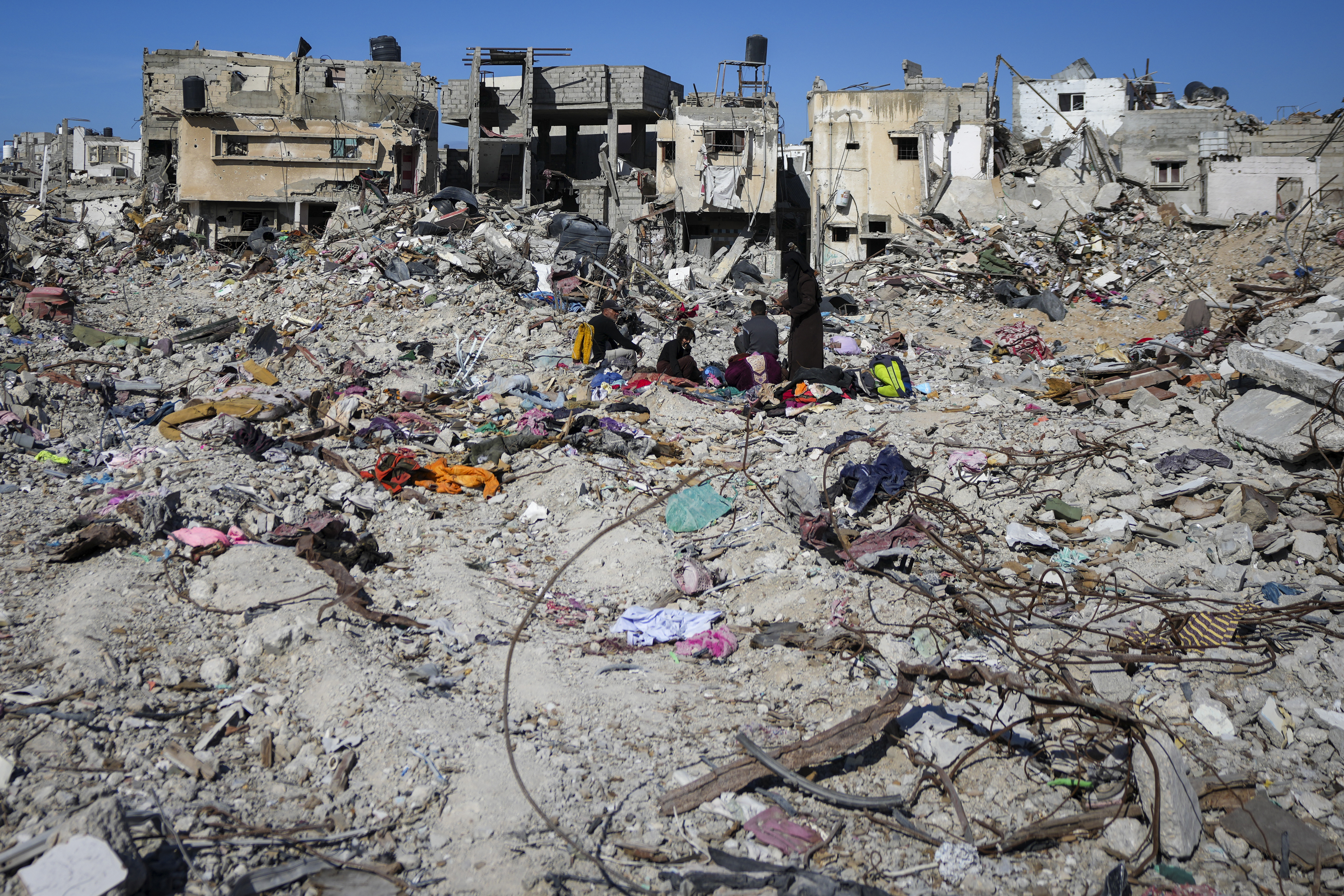 Palestinians search for their belongings under the rubble of destroyed homes a day after a ceasefire deal between Israel and Hamas took effect, in Rafah, southern Gaza Strip, Monday, Jan. 20, 2025. (AP Photo/Abdel Kareem Hana)