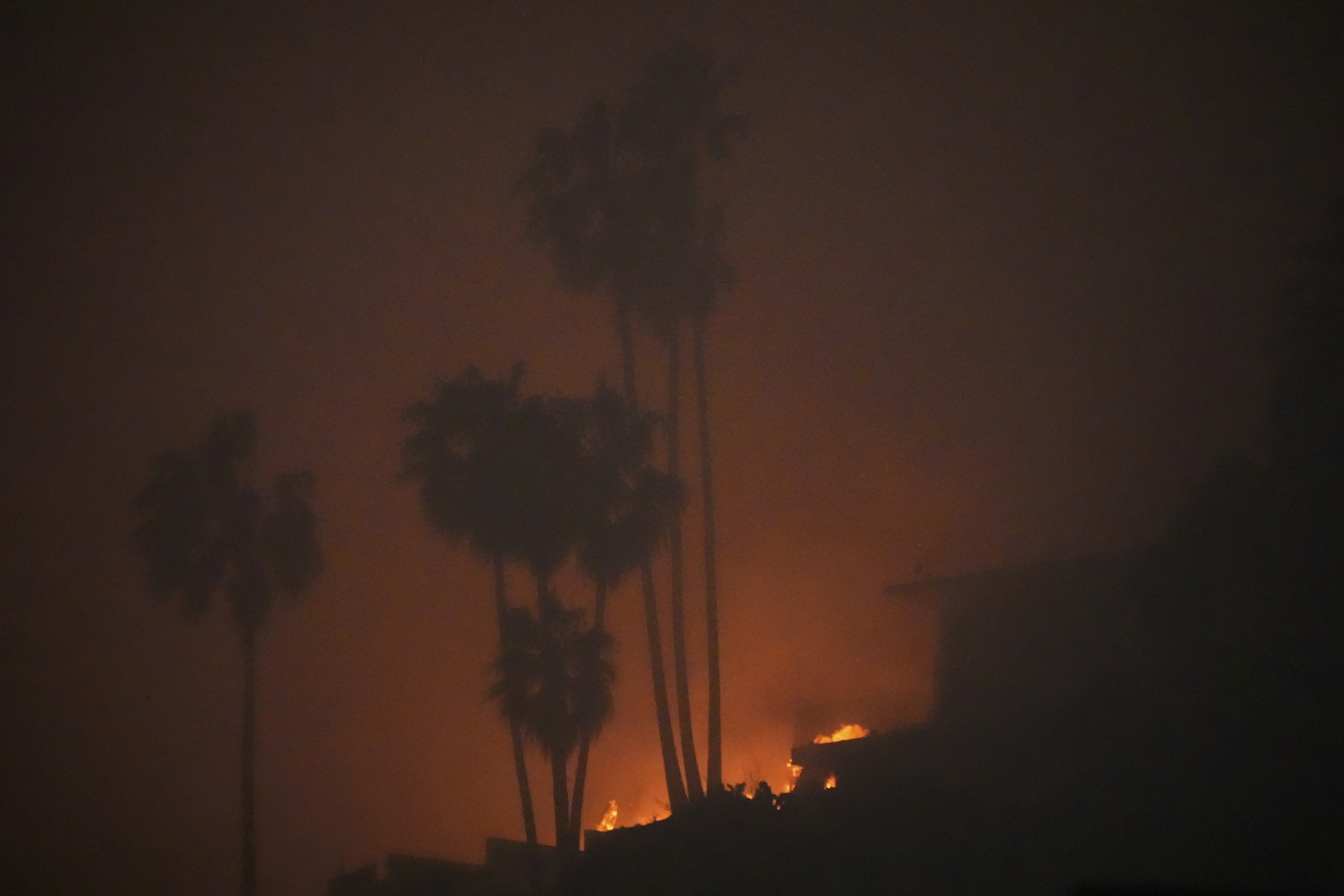 The Palisades Fire ravages a neighborhood amid high winds in the Pacific Palisades neighborhood of Los Angeles, Wednesday, Jan. 8, 2025. (AP Photo/Damian Dovarganes)