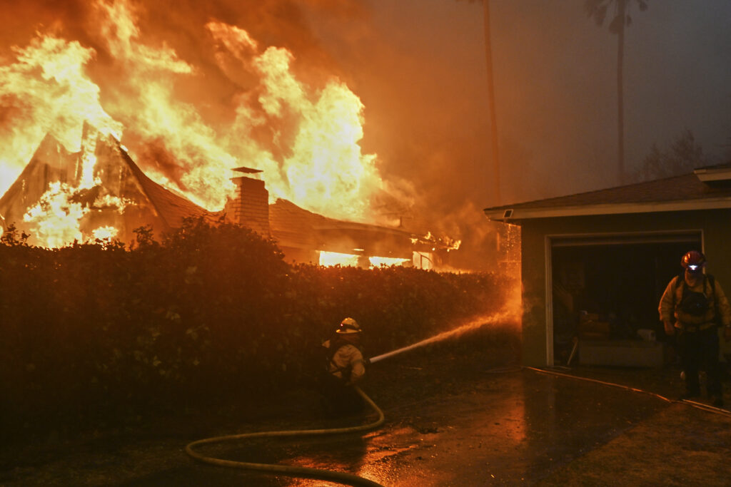 Fire crews battle the Eaton Fire next to a fully engulfed residence, Wednesday, Jan. 8, 2025 in Altadena, Calif. (AP Photo/Nic Coury)