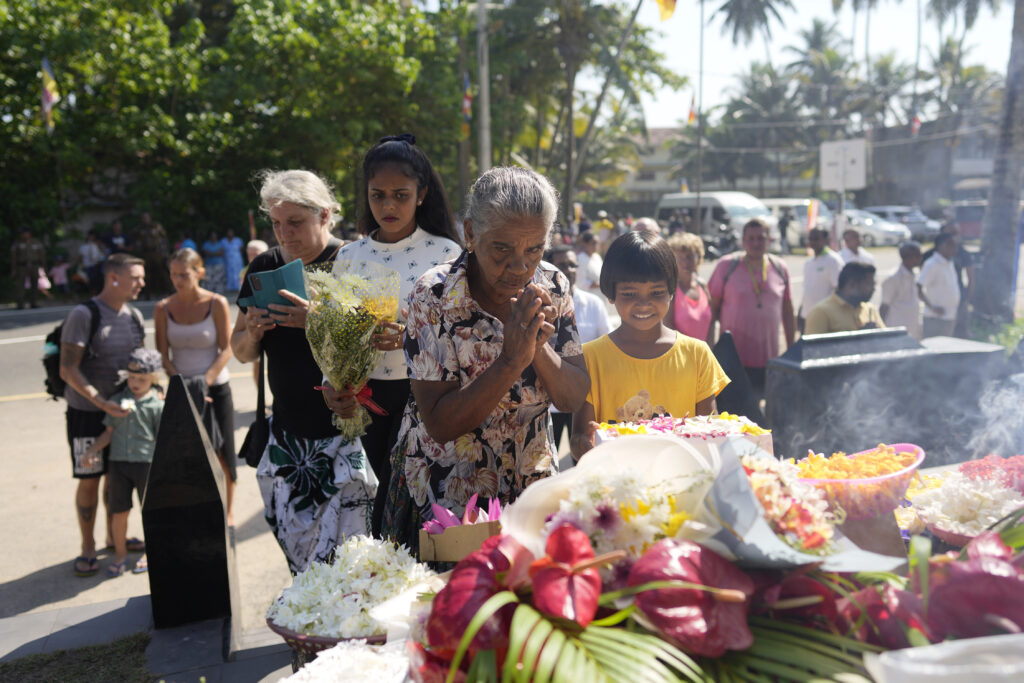 Relatives of tsunami victims offer floral tributes at a memorial built in memory of those who died during 2004 Indian Ocean tsunami as they mark the 20th anniversary in Peraliya, Sri Lanka, Thursday, Dec. 26, 2024. (AP Photo/Eranga Jayawardena)