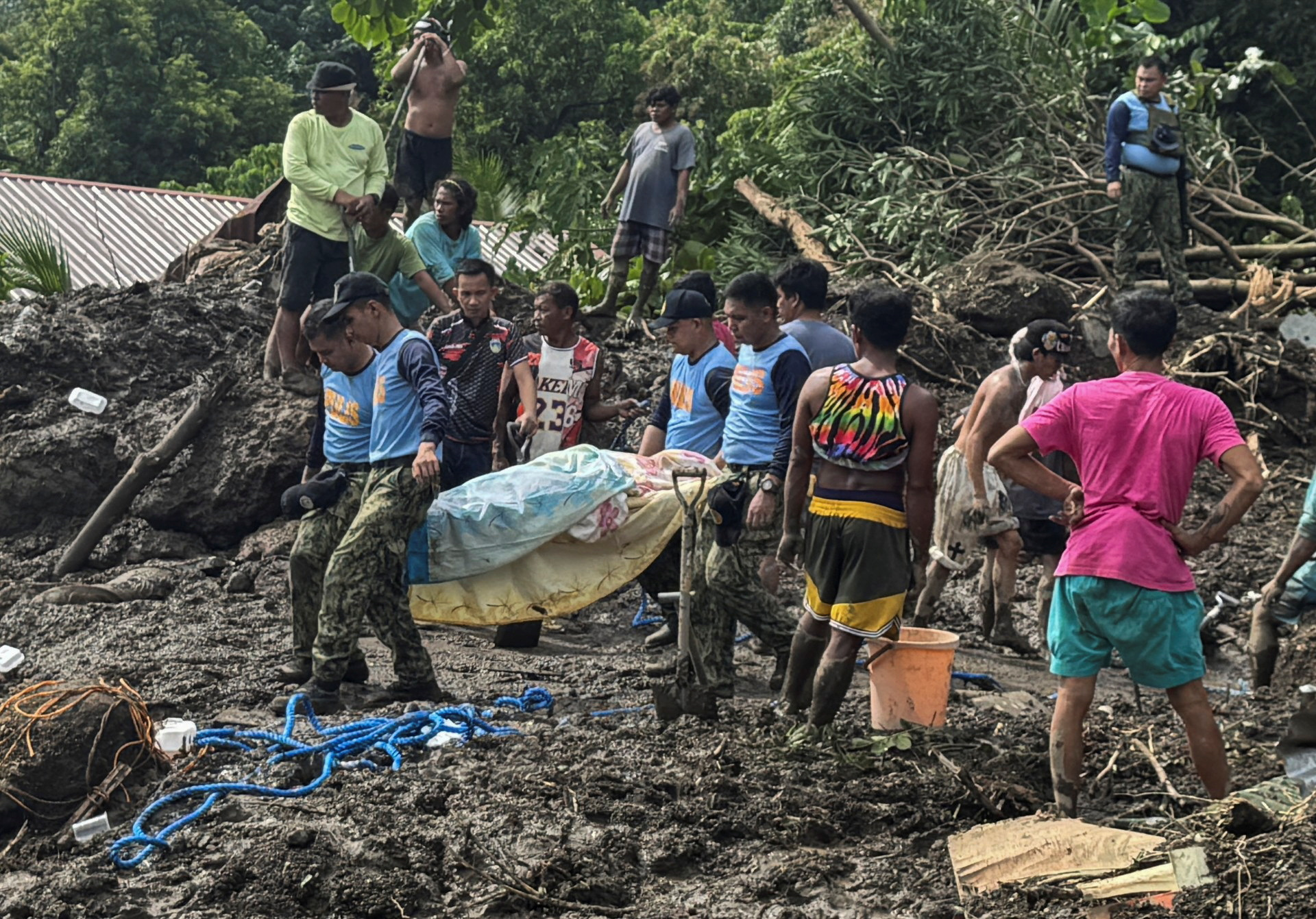Rescue personnel and residents carrying casualties of a landslide in Batangas province, Philippines, October 25, 2024. REUTERS/Jay Ereno