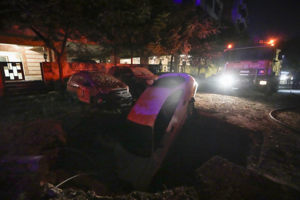 A car sits in a hole at the site of an Israeli airstrike in Beirut's southern suburbs Friday, Sept. 27, 2024. (AP Photo/Bilal Hussein)