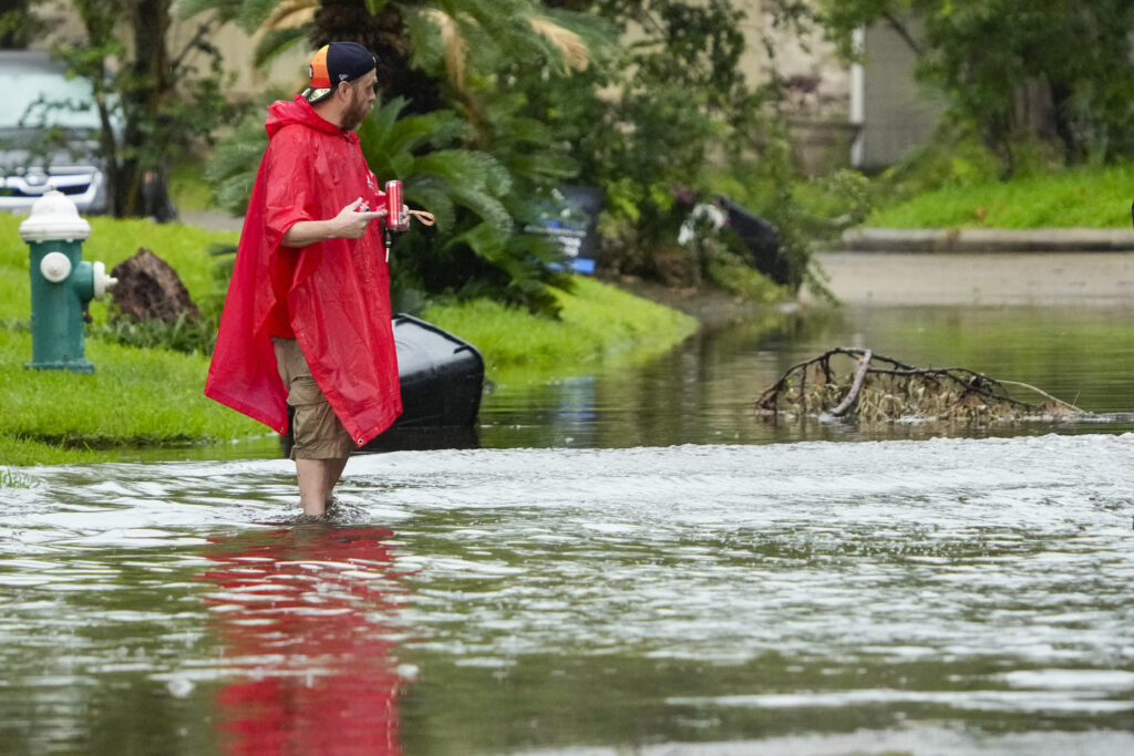 Darren Bynum stands in some street flooding following a heavy rain storm that swept through the Houston area on Tuesday, May 28, 2024, in Spring, Texas. (Brett Coomer/Houston Chronicle via AP)