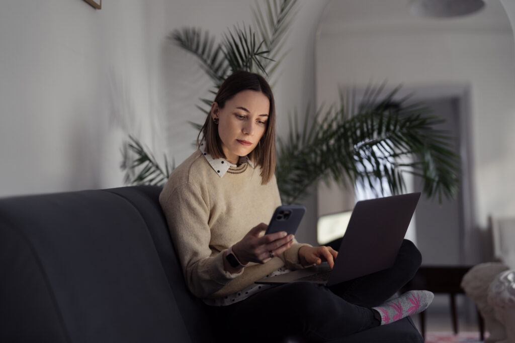Caucasian Woman using laptop while sitting on the sofa at home in the evening living room typing on the phone, Pr tekst philip Morris,
