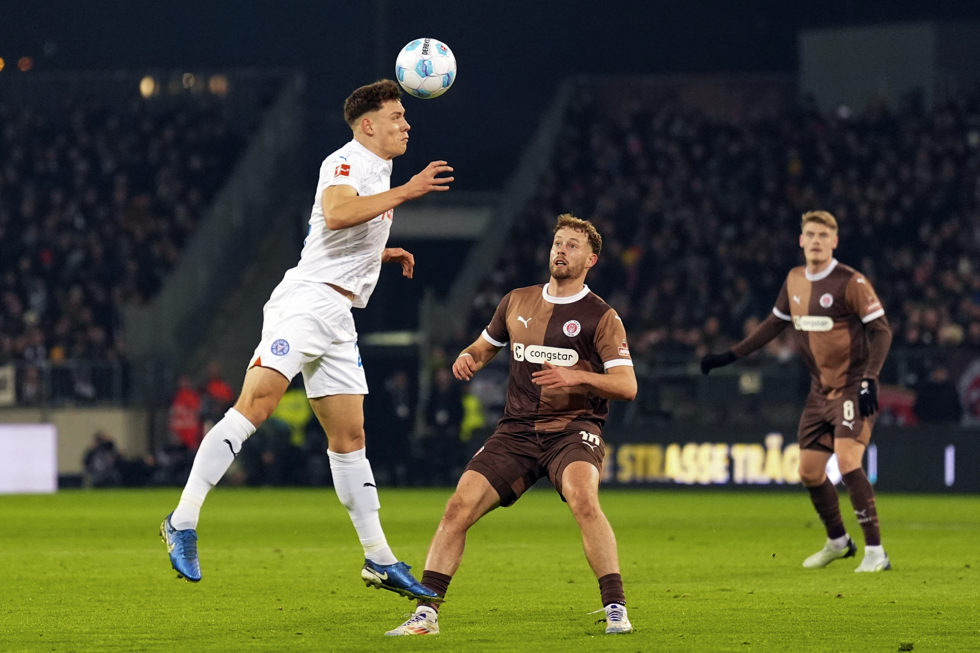Kiel's Nicolai Remberg, left, and St. Pauli's Carlo Boukhalfa battle for the ball during the Bundesliga soccer match between FC St. Pauli and Holstein Kiel at the Millerntor Stadium, Hamburg, Germany, Friday Nov. 29, 2024. (Marcus Brandt/dpa via AP)