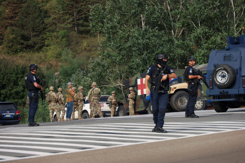 People work as Kosovo police and U.S. and EU troops stand by after one police officer was killed, another hurt in Kosovo gunfire, in Josevik, Kosovo September 24, 2023. REUTERS/Fatos Bytyci