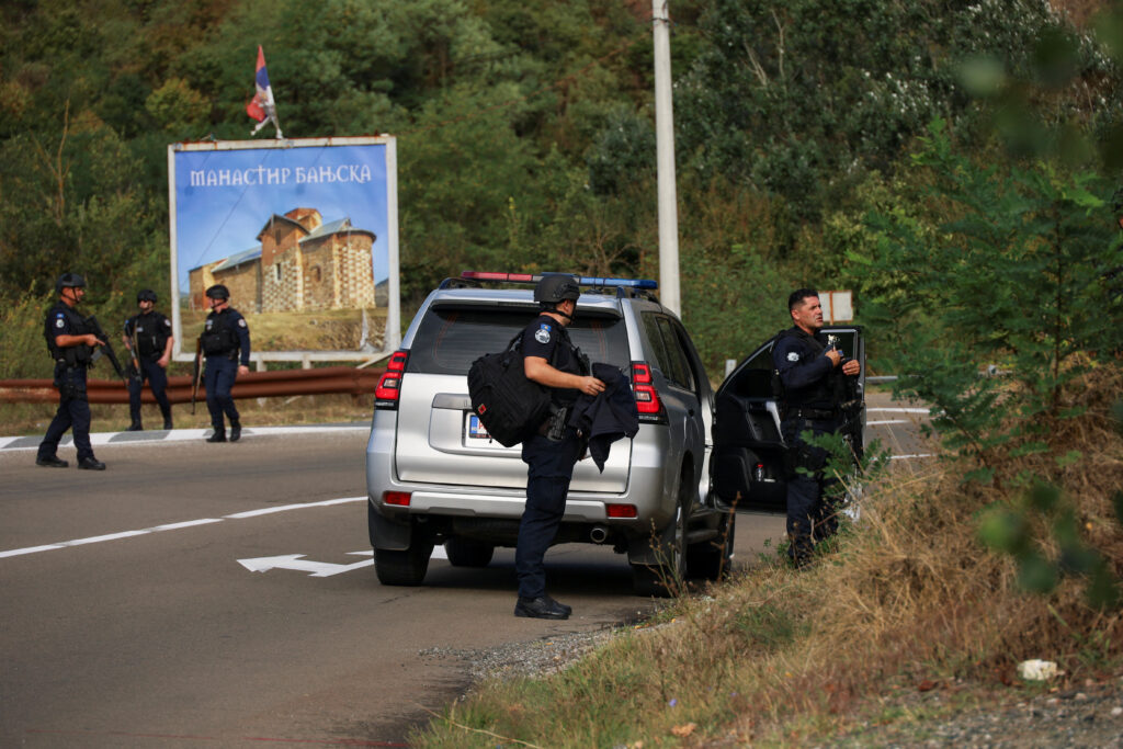 People work as Kosovo police and U.S. and EU troops stand by after one police officer was killed, another hurt in Kosovo gunfire, in Josevik, Kosovo September 24, 2023. REUTERS/Fatos Bytyci