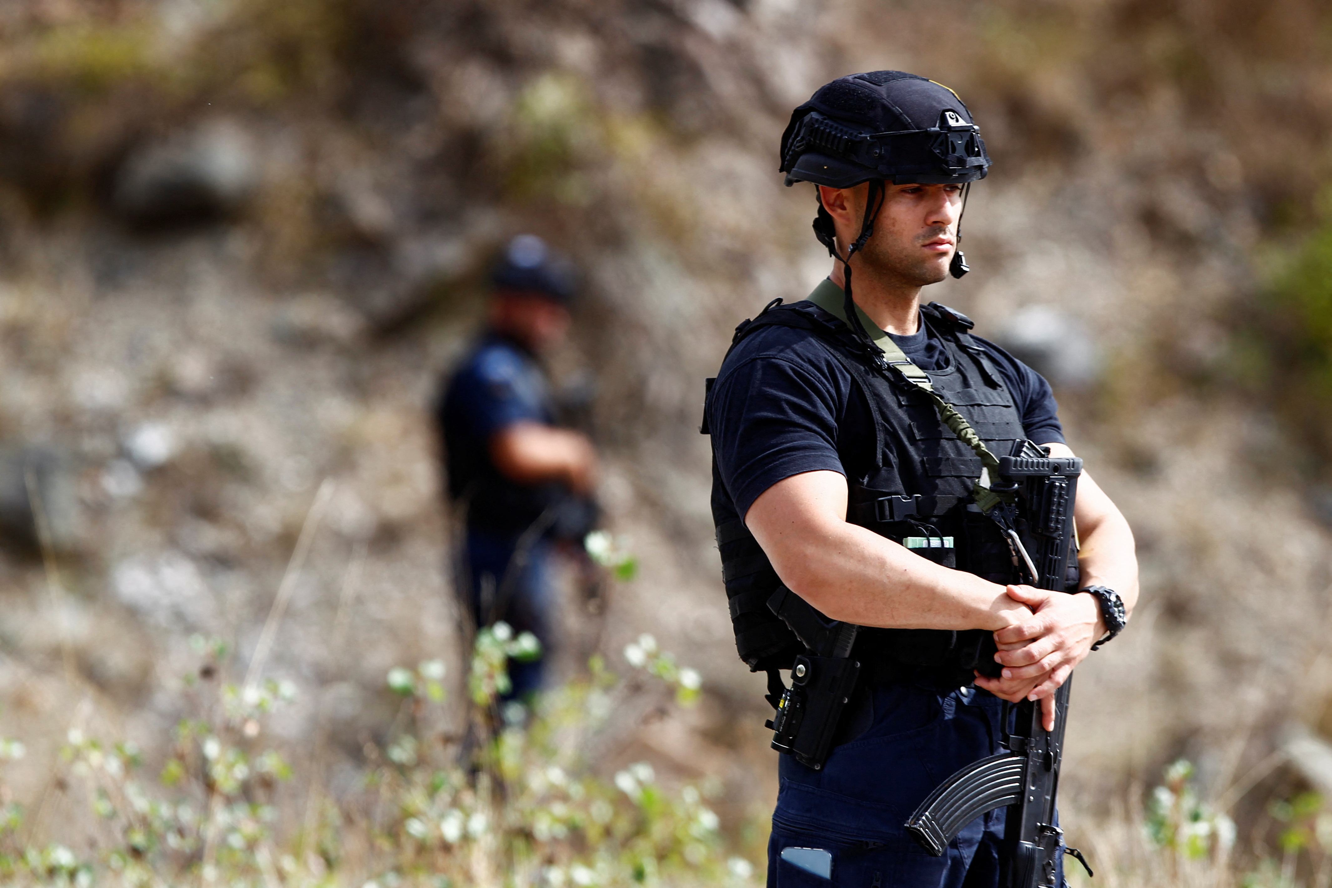 A police officer stands guard in the aftermath of a shooting, near the village of Zvecane, Kosovo September 24, 2023. REUTERS/Ognen Teofilovski