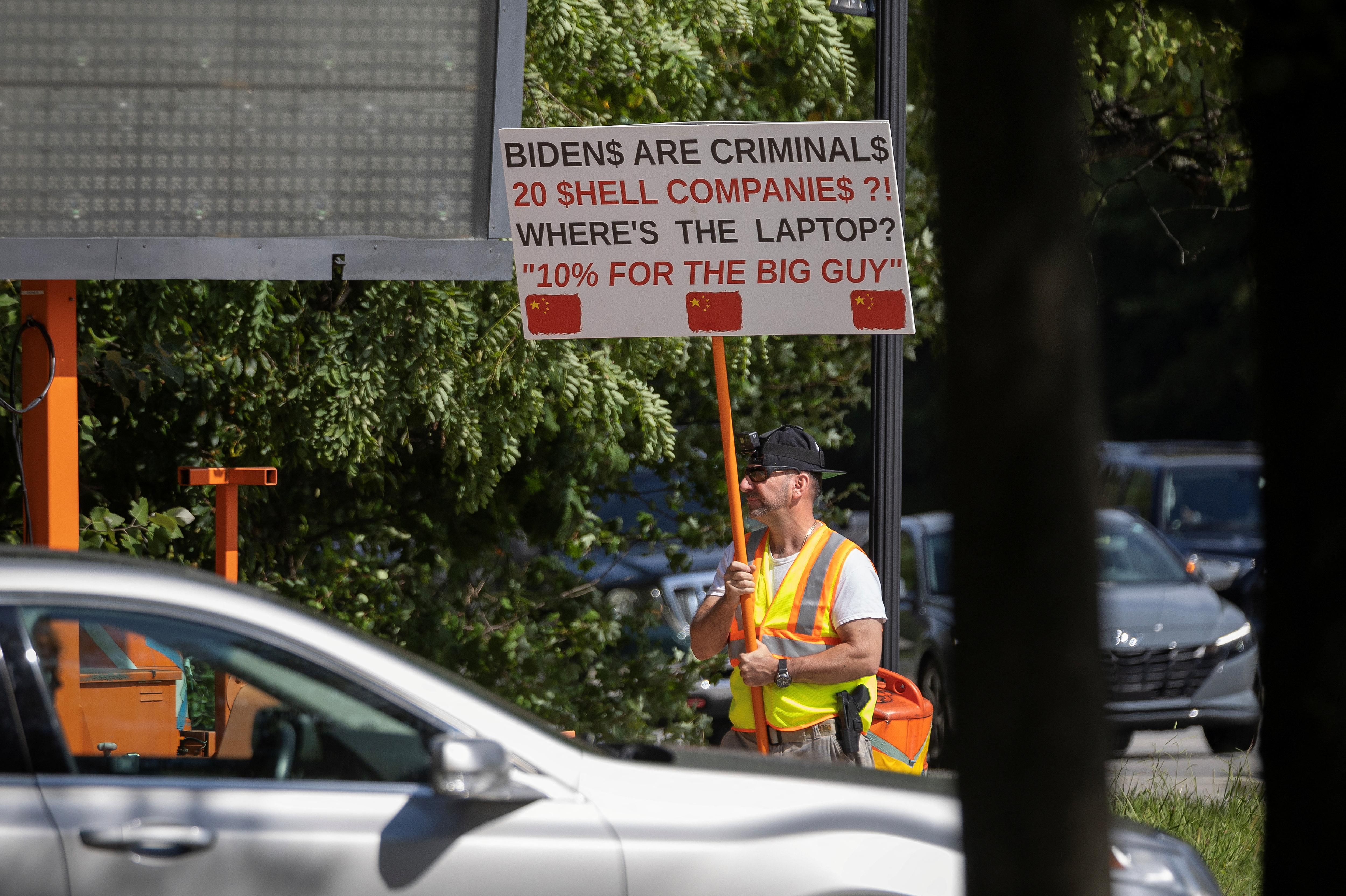 An armed demonstrator carries a sign along Barley Mill Road near the residence of U.S. President Joe Biden in Wilmington