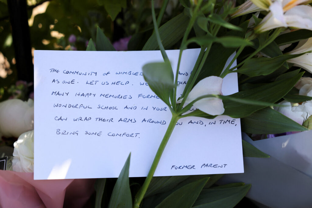 Floral tributes are laid outside a school gate after an eight-year-old girl died after a car crashed into The Study Preparatory School in Wimbledon, London, Britain, July 7, 2023, REUTERS/Hollie Adams