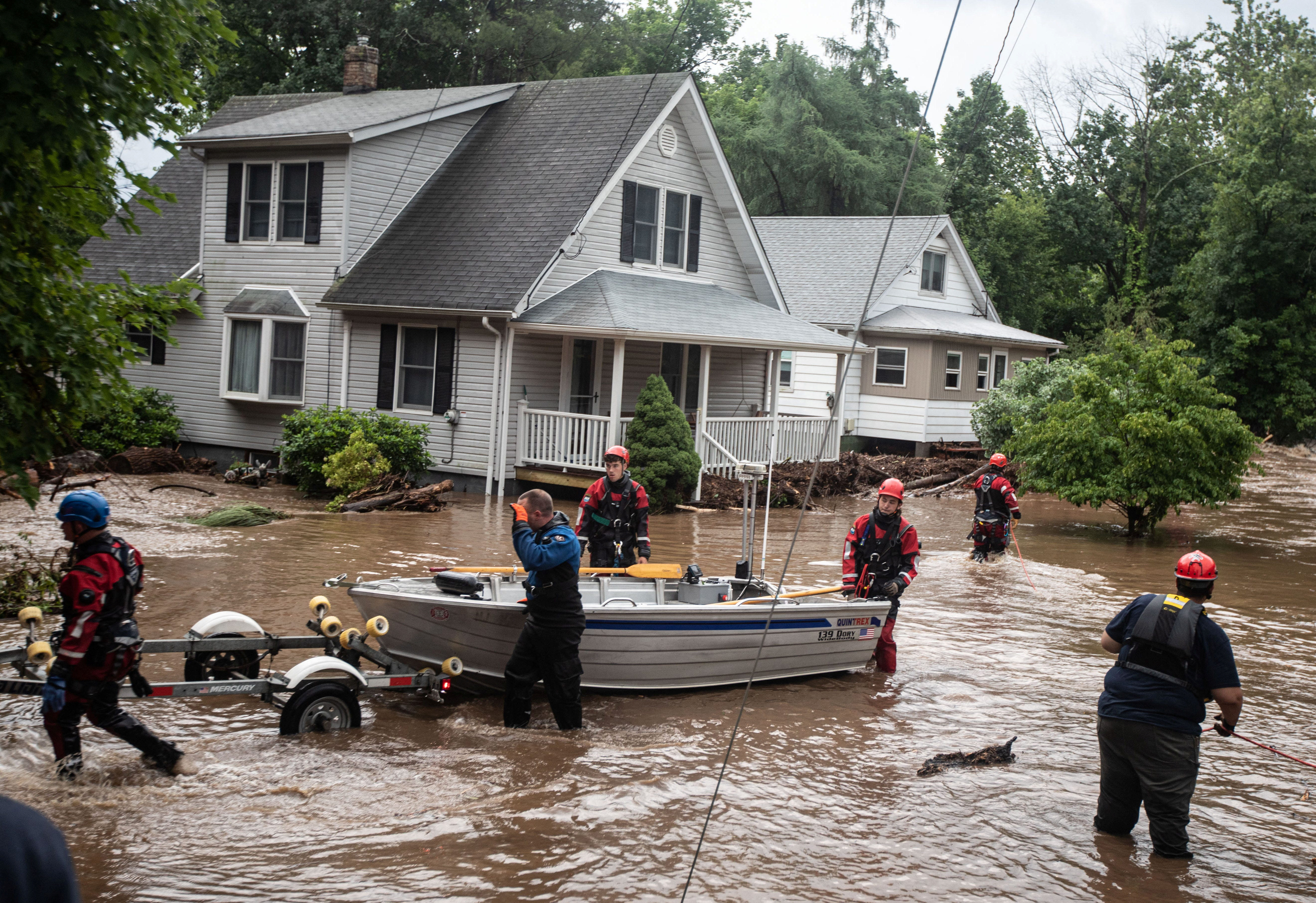 njujork poplave,Emergency personnel maneuvre a boat which was used to rescue residents in Stony Point