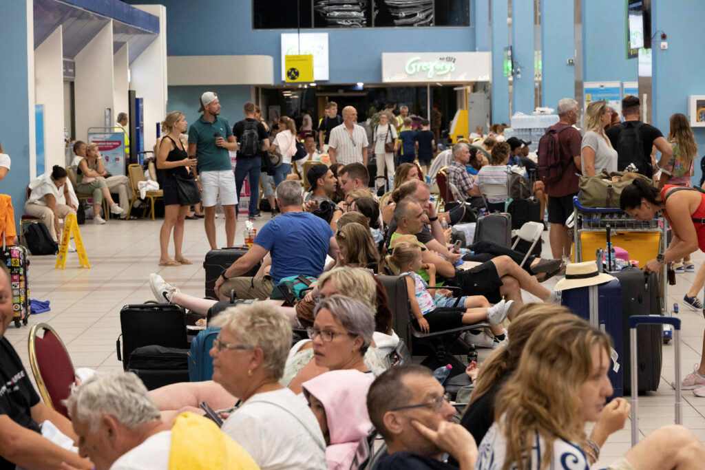 Tourists wait for departing planes at the airport, after being evacuated following a wildfire on the island of Rhodes, Greece, July 24, 2023. REUTERS/Nicolas Economou