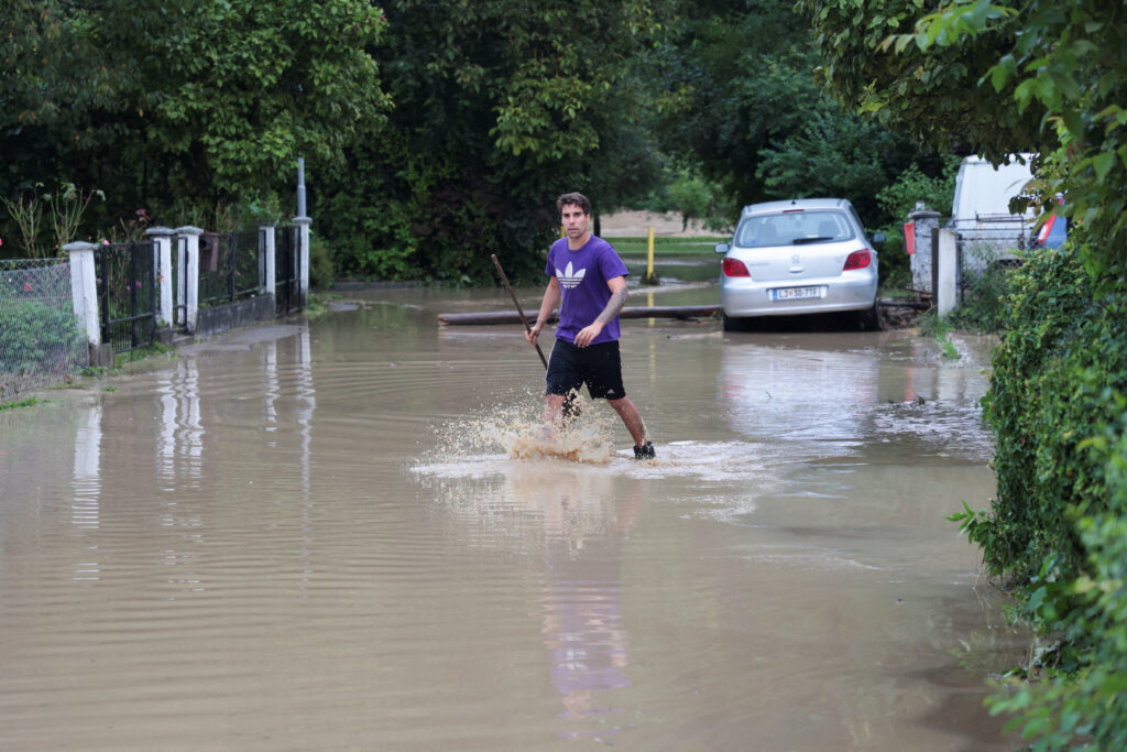 A man wades in water during floods in Domzale, Slovenia August 4, 2023. REUTERS/Borut Zivulovic