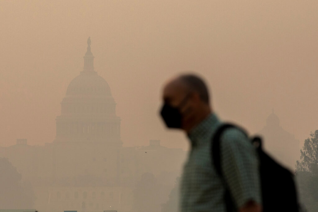 A person walks on the National Mall as the U.S. Capitol is seen shrouded in haze and smoke caused by wildfires in Canada, in Washington, U.S., June 8, 2023. REUTERS/Amanda Andrade-Rhoades