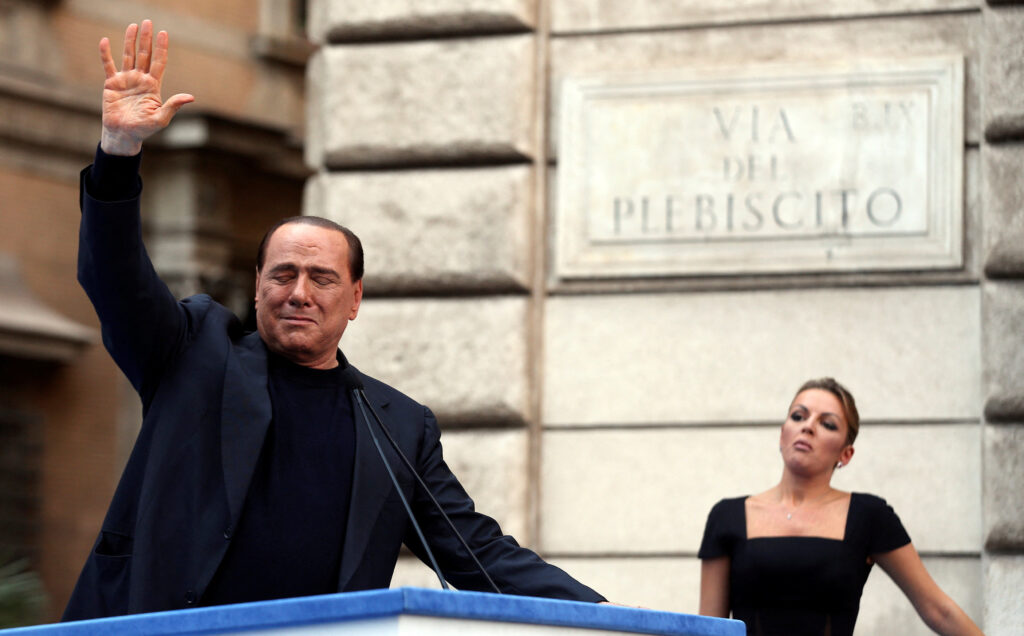 FILE PHOTO: Former Italian Prime Minister Silvio Berlusconi waves to supporters as his girlfriend Francesca Pascale looks on during a rally to protest his tax fraud conviction, in central Rome, Italy, August 4, 2013.  REUTERS/Alessandro Bianchi/File Photo