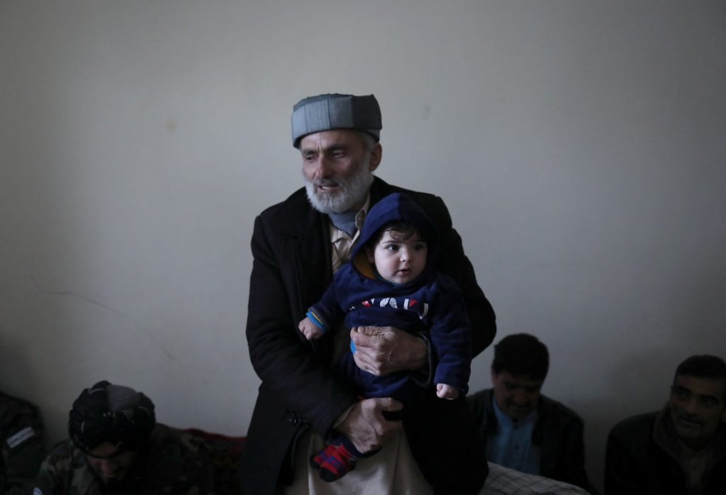 Mohammad Qasem Razawi, grandfather of baby Sohail Ahmadi, holds him at the house of Hamid Safi, a 29-year-old taxi driver who had found the baby in the airport, in Kabul, Afghanistan, January 8, 2022. Picture taken January 8, 2022. REUTERS/Ali Khara