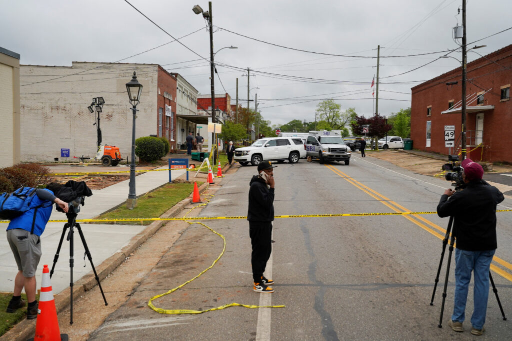 Community members and media stand near the crime scene, a day after a shooting at a teenager's birthday party in a dance studio, in Dadeville, Alabama, U.S., April 16, 2023.  REUTERS/Cheney Orr