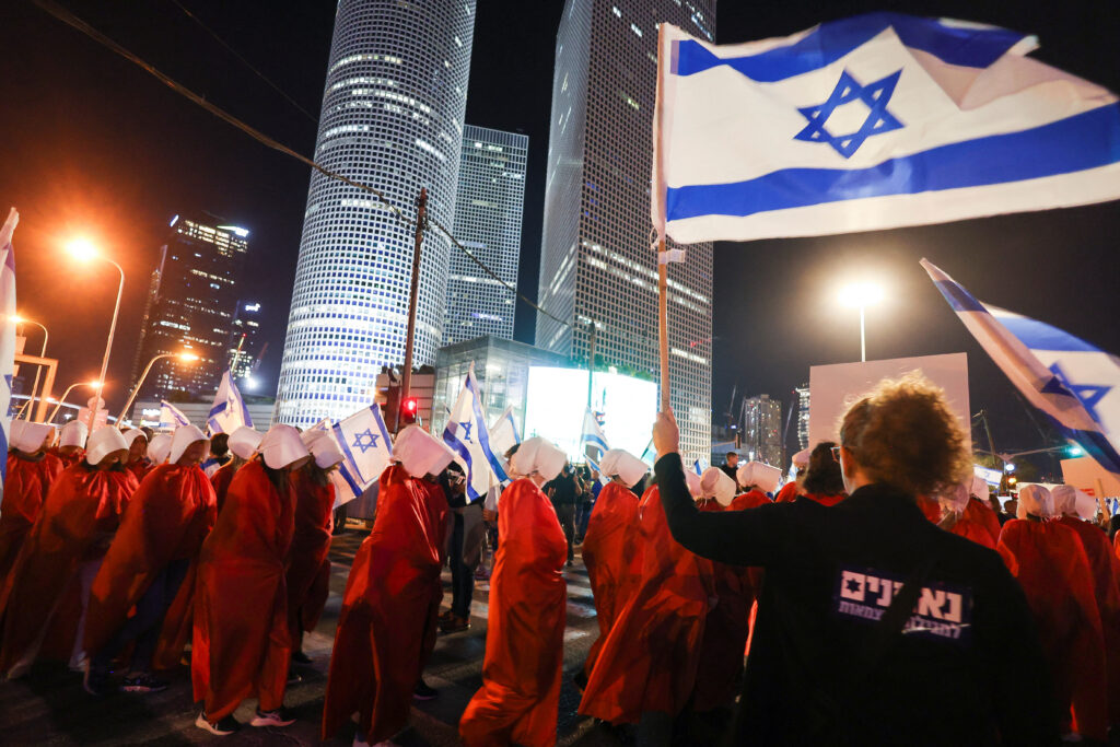 People hold Israeli flags during a demonstration as Israeli Prime Minister Benjamin Netanyahu's nationalist coalition government presses on with its contentious judicial overhaul, in Tel Aviv, Israel, March 11, 2023. REUTERS/Nir Elias