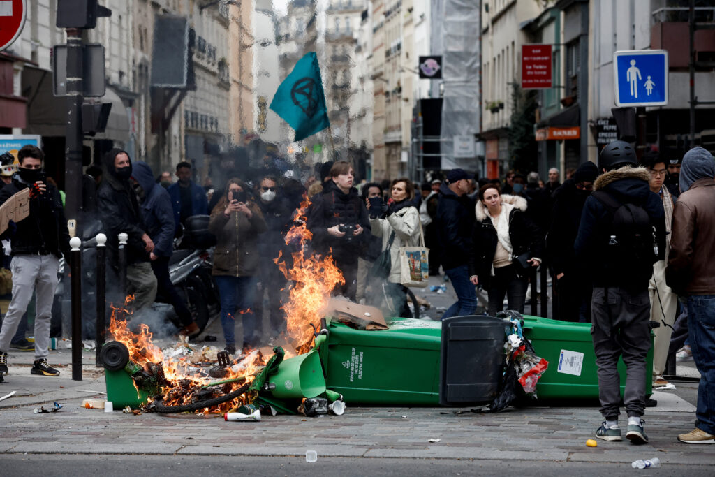 Flames emerge as people attend a march against the government's pension reform plan in Paris, France, March 11, 2023.  REUTERS/Benoit Tessier