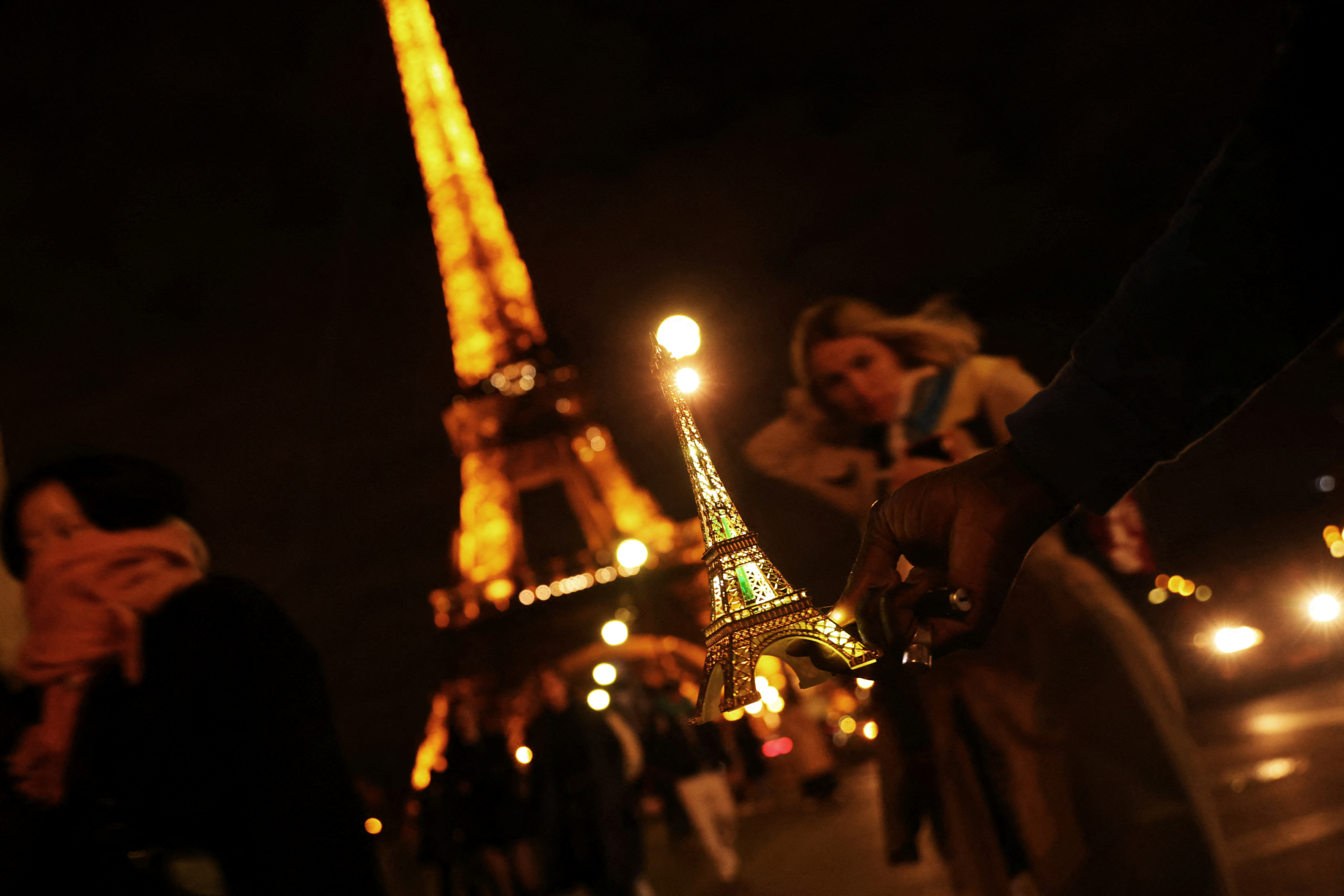 A man sells miniatures of the Eiffel Tower to tourists in Paris, France, March 27, 2023. REUTERS/Nacho Doce