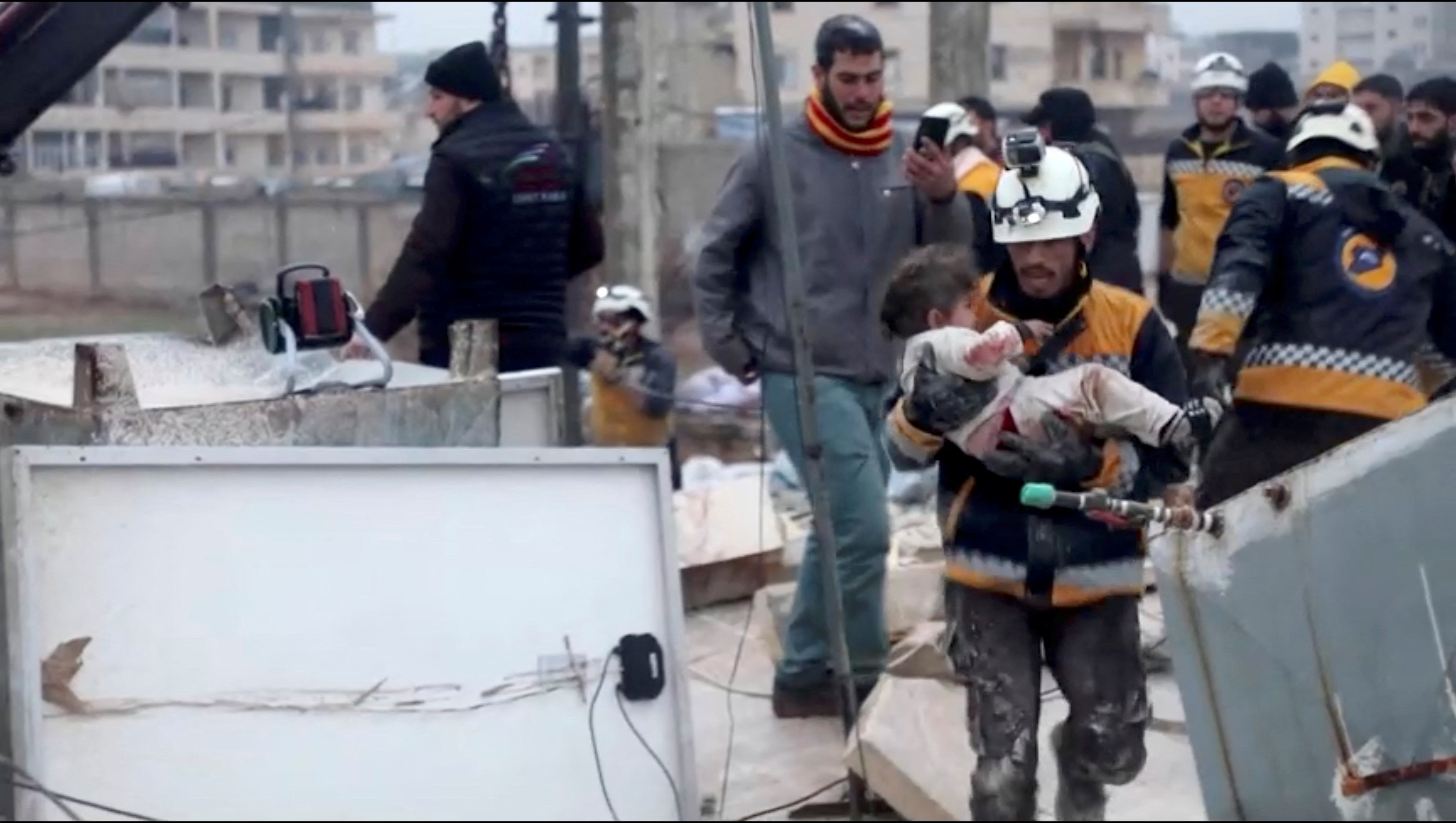 A rescuer carries an injured child away from the rubble of a building following an earthquake in rebel-held Azaz, Syria February 6, 2023 in this still image taken from video.  REUTERS/via Reuters TV