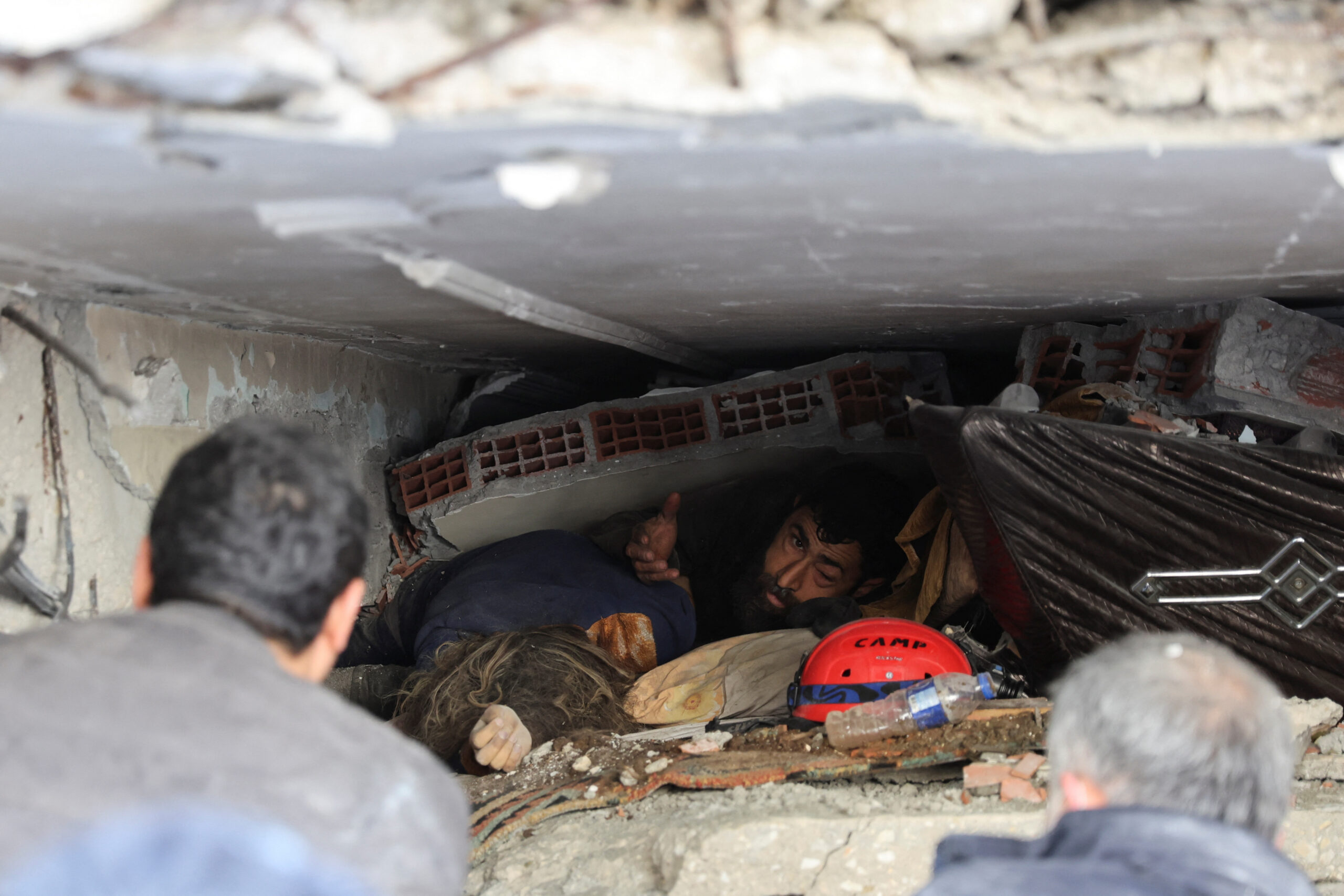 SENSITIVE MATERIAL. THIS IMAGE MAY OFFEND OR DISTURB    Abdulalim Muaini lies under the rubble next to the body of his wife Esra, in the aftermath of a deadly earthquake in Hatay, Turkey, February 8, 2023. REUTERS/Umit Bektas