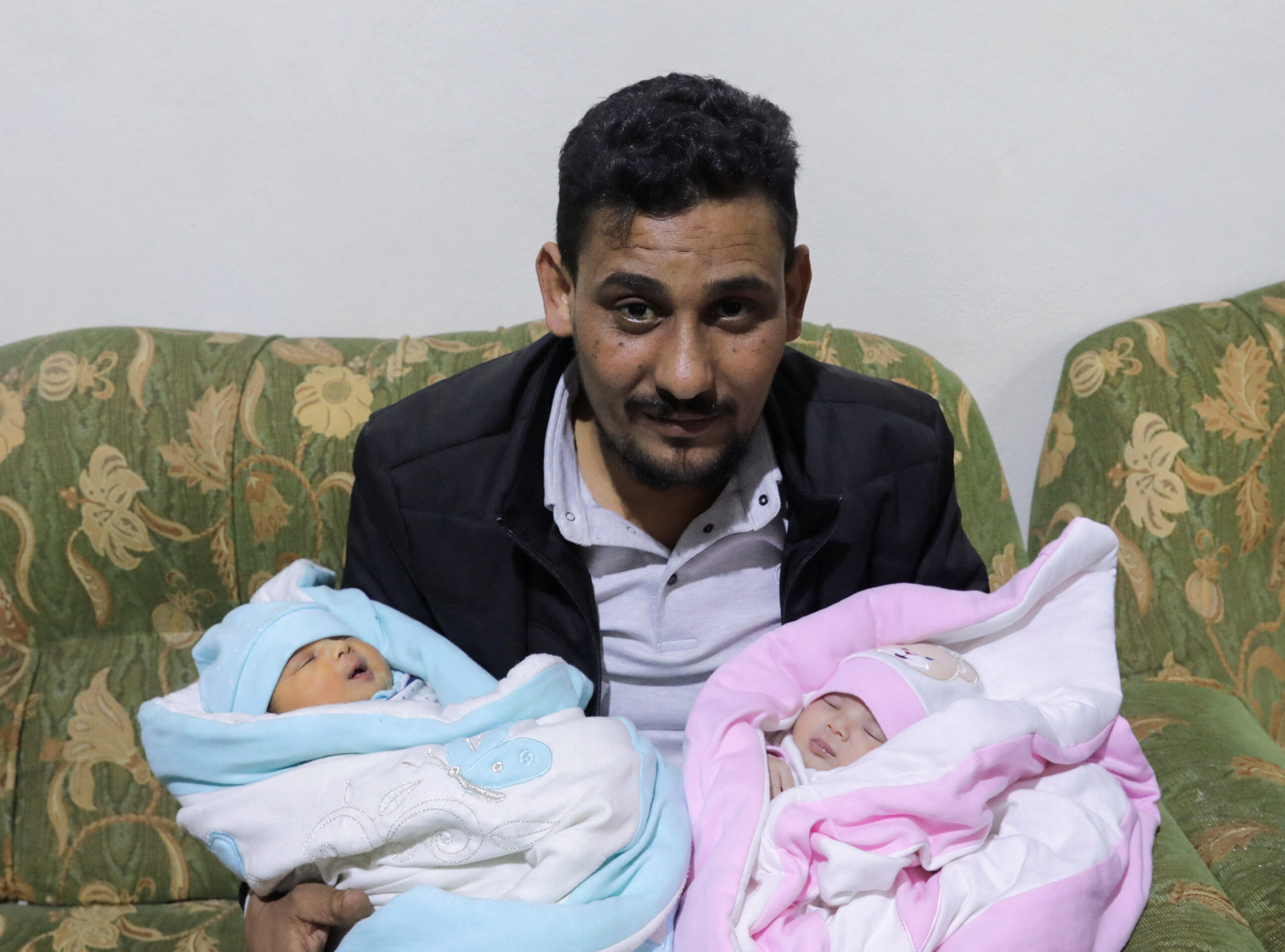 Khalil Al-Sawadi, the uncle-by-marriage of a baby girl born during a deadly earthquake earlier this month, holds her and his own newborn daughter, in Jandaris, Syria February 18, 2023.  REUTERS/Khalil Ashawi