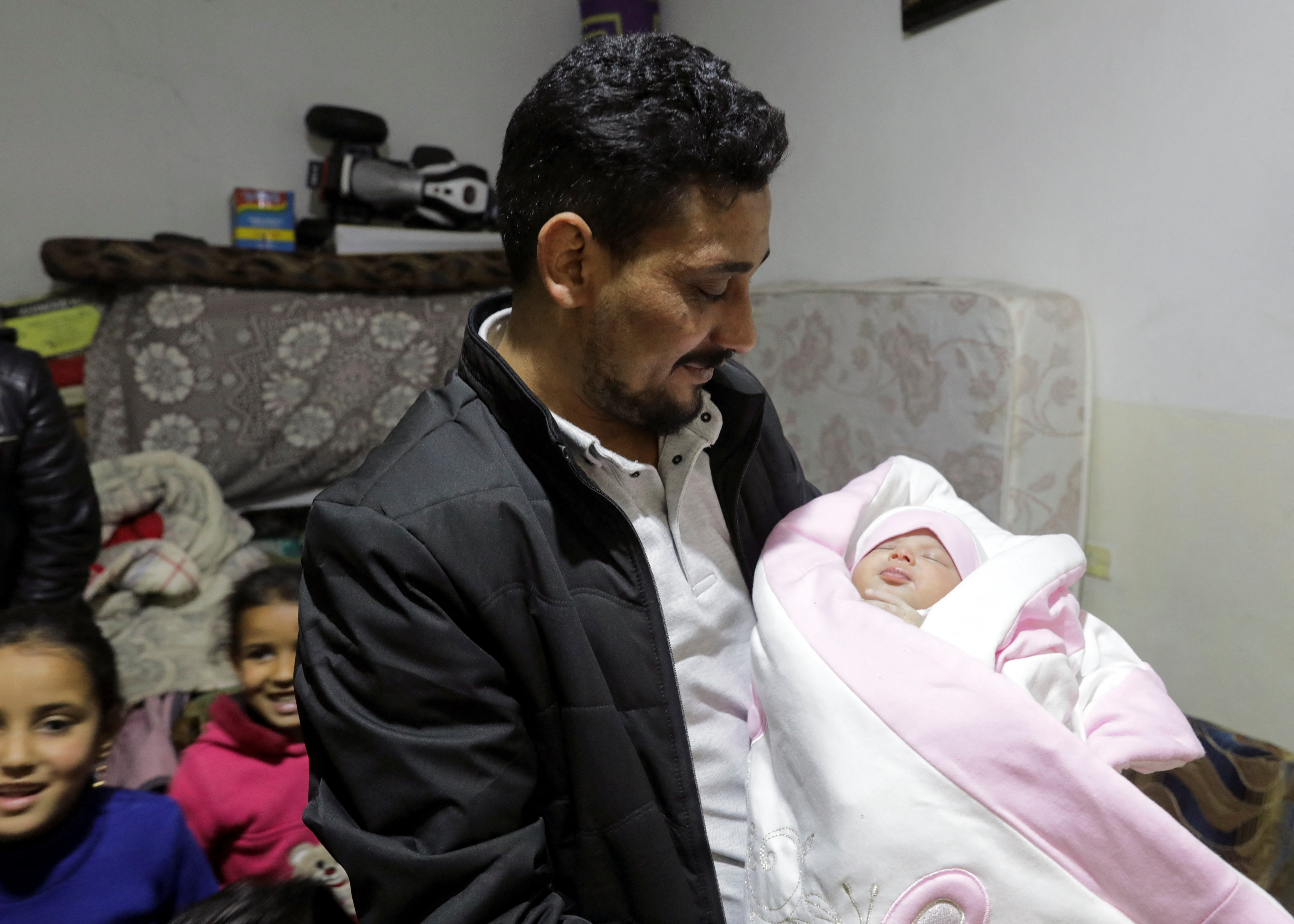 Khalil Al-Sawadi, the uncle-by-marriage of a baby girl born during a deadly earthquake earlier this month, holds her, in rebel-held town of Jandaris, Syria February 18, 2023.  REUTERS/Khalil Ashawi