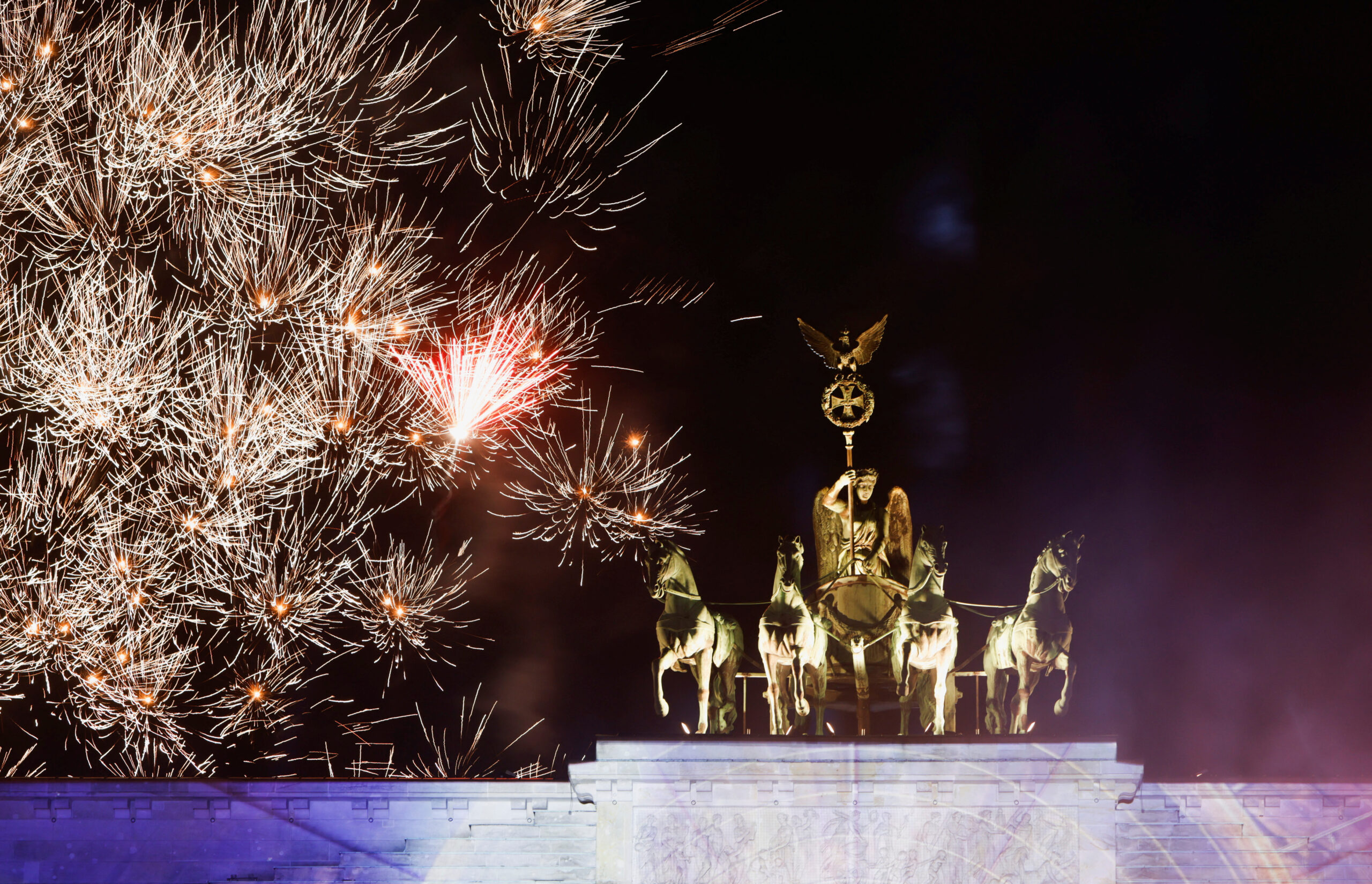 Fireworks explode behind the Brandenburg Gate ahead of the New Year, in Berlin, Germany, December 31, 2022. REUTERS/Michele Tantussi