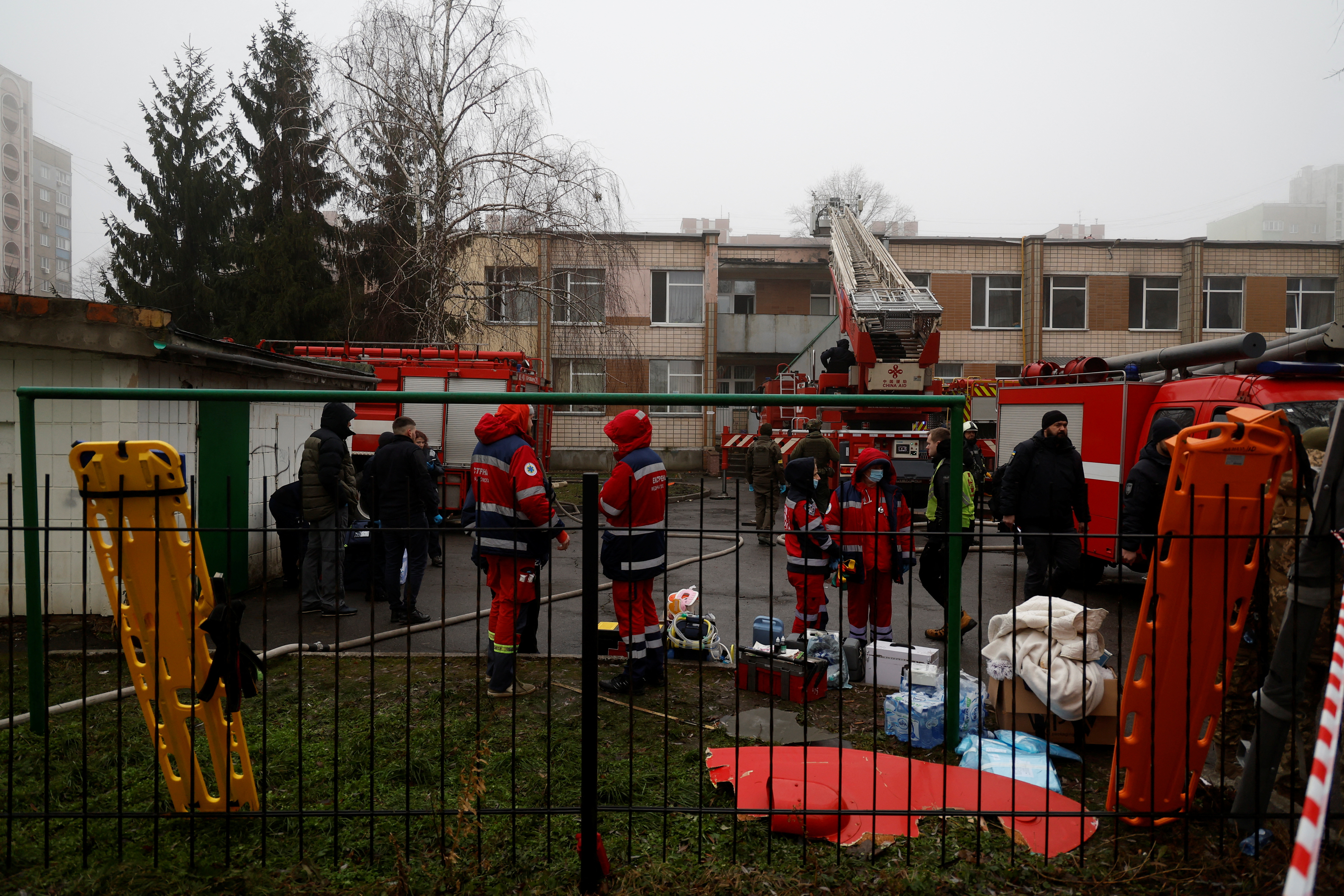 Medics and emergency personnel work at the site a where a helicopter falls on civil infrastructure buildings, amid Russia's attack on Ukraine, in the town of Brovary, outside Kyiv, Ukraine, January 18, 2023. REUTERS/Valentyn Ogirenko