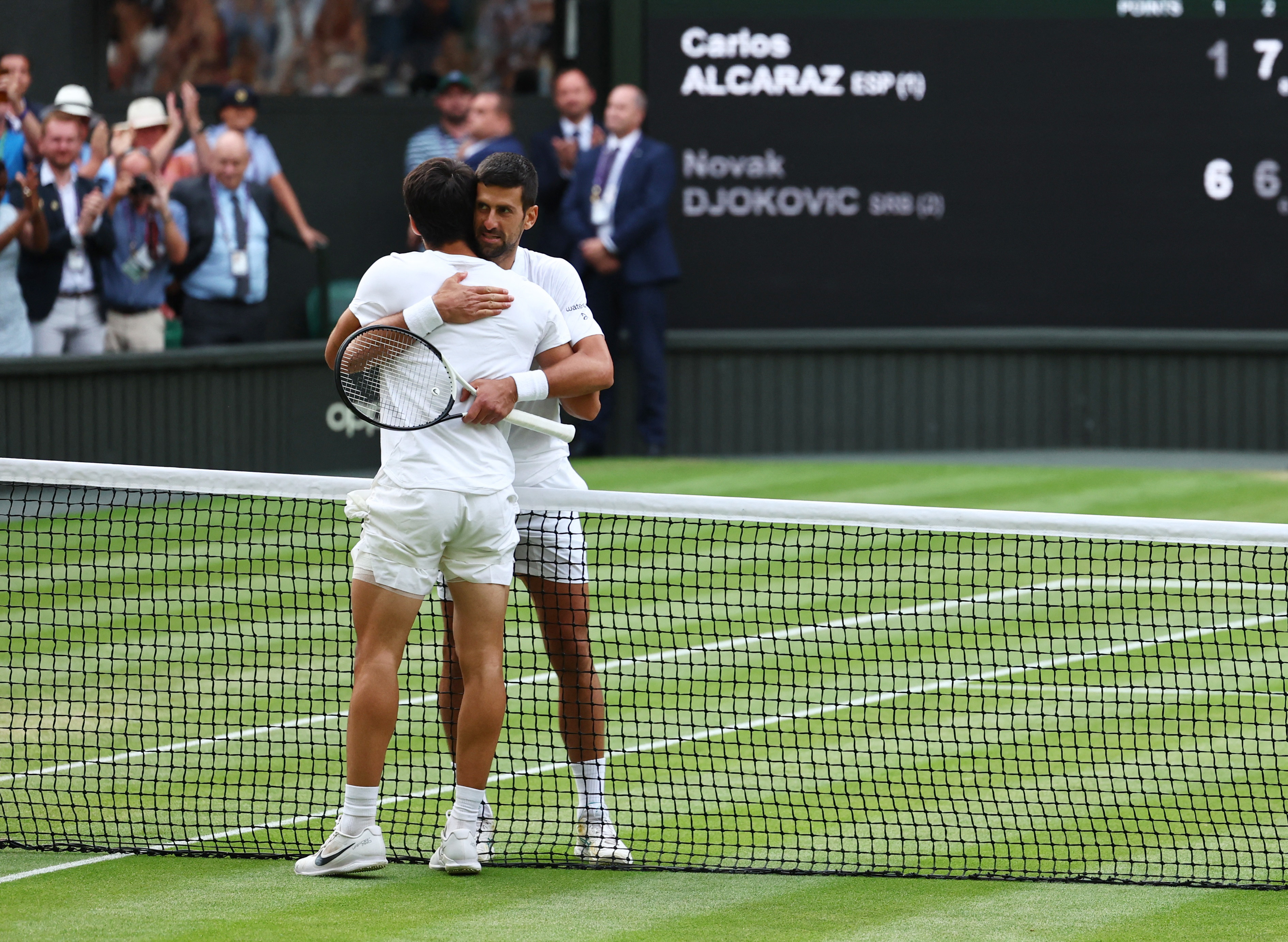Tennis - Wimbledon - All England Lawn Tennis and Croquet Club, London, Britain - July 16, 2023 Spain's Carlos Alcaraz with Serbia's Novak Djokovic after winning the final REUTERS/Toby Melville