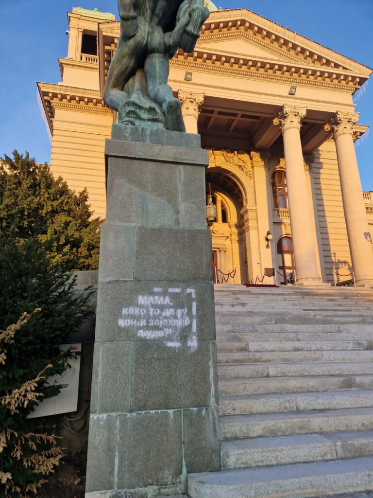 Andrej Josifovski Pijanista, arhitekta i umetnik uhapšen je ispred Skupštine Srbije nakon što je sneg sprejom na ulazu zgrade napisao "Mama, kako to da su konji zajahali ljude?"