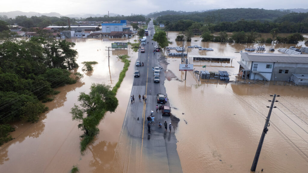 People gather on a road surrounded in a flooded area after heavy rains in Canelinha, in Santa Catarina state, Brazil, December 1, 2022. REUTERS/Anderson Coelho NO RESALES. NO ARCHIVES.