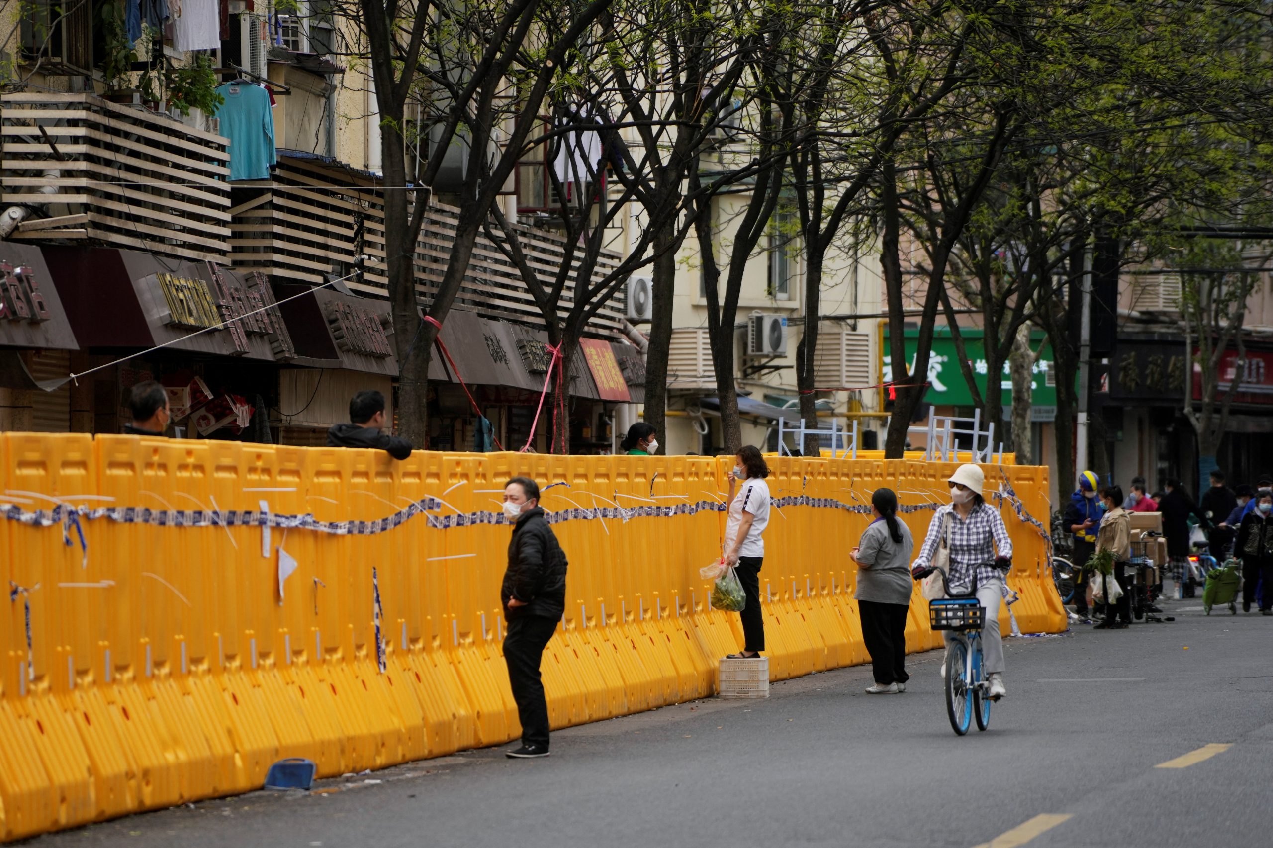 Food vendors stand behind barricades of a sealed-off area, following the coronavirus disease (COVID-19) outbreak in Shanghai, China March 30, 2022. REUTERS/Aly Song